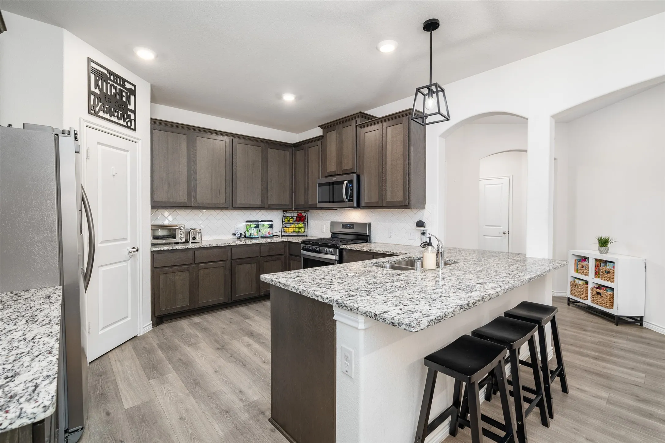 Granite Countertops, tile backsplash, large breakfast bar, open to dining and living areas.