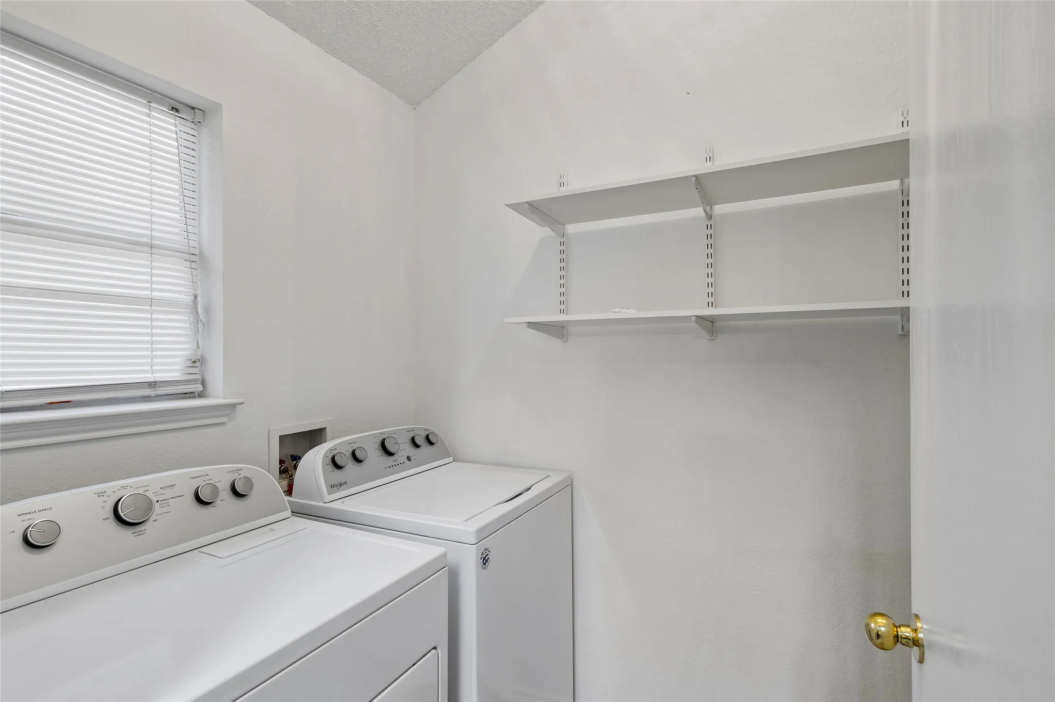 Nice size Utility room with lots of shelves for storage. Note the washer & dryer can stay.