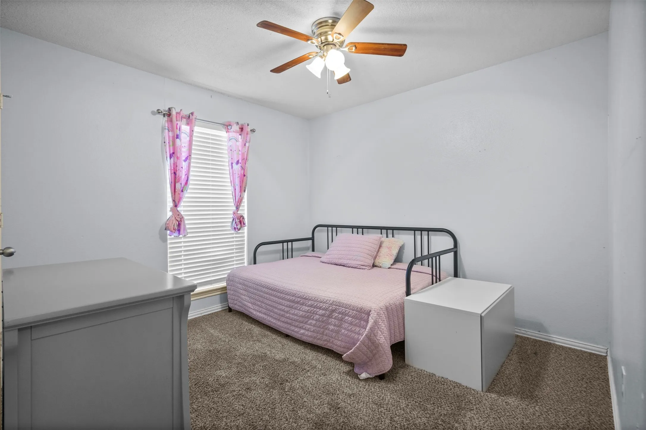 Bedroom featuring a ceiling fan with light fixture, window with blinds, and carpet flooring