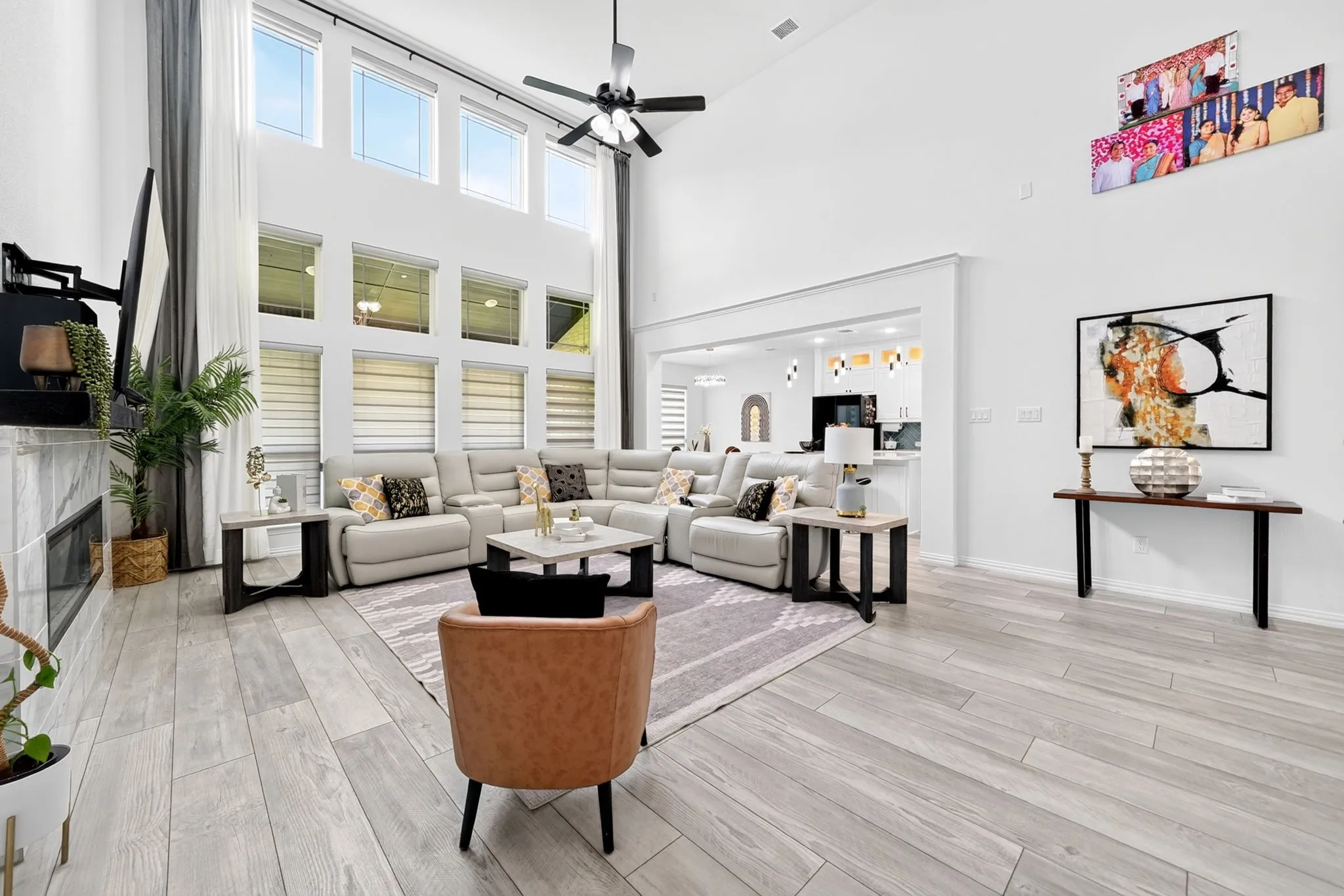 Two-story living area featuring wood-finish flooring and a contemporary fireplace with a stone surround