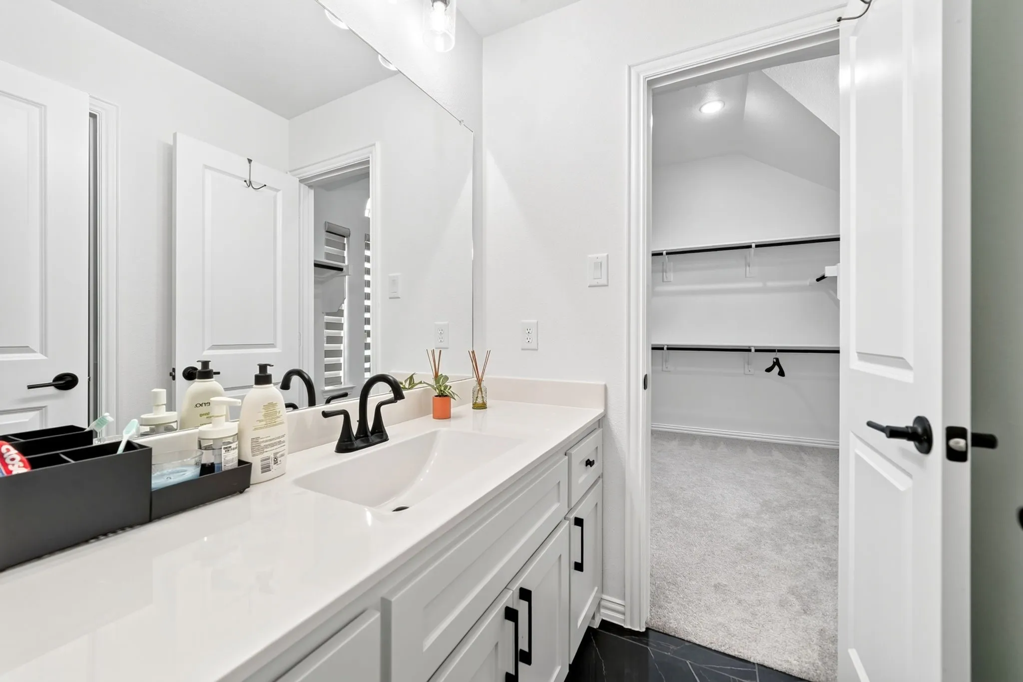 Contemporary vanity with white countertop, integrated sink, and matte black fixtures