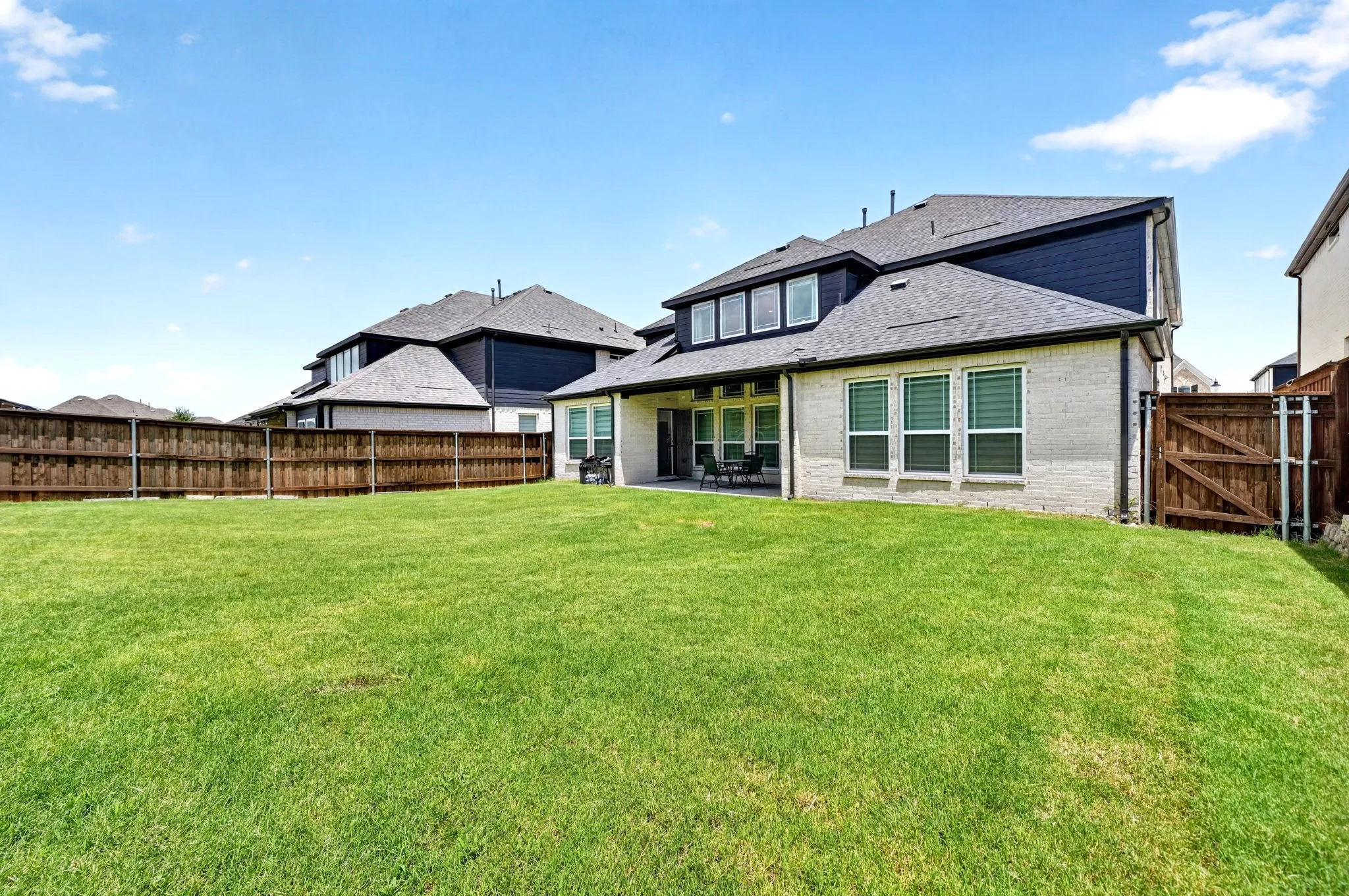 Expansive green lawn with a full wooden privacy fence