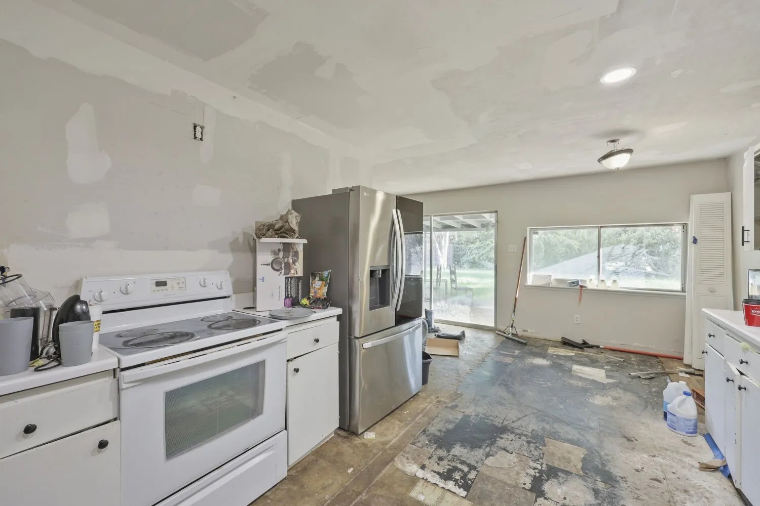 Kitchen space featuring white cabinetry, a white electric range, and a stainless steel side-by-side refrigerator