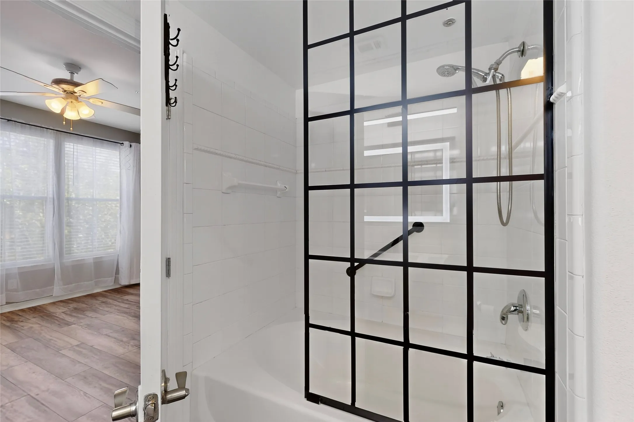 Full bathroom with shower / bath combination, a ceiling fan, and wood finished floors