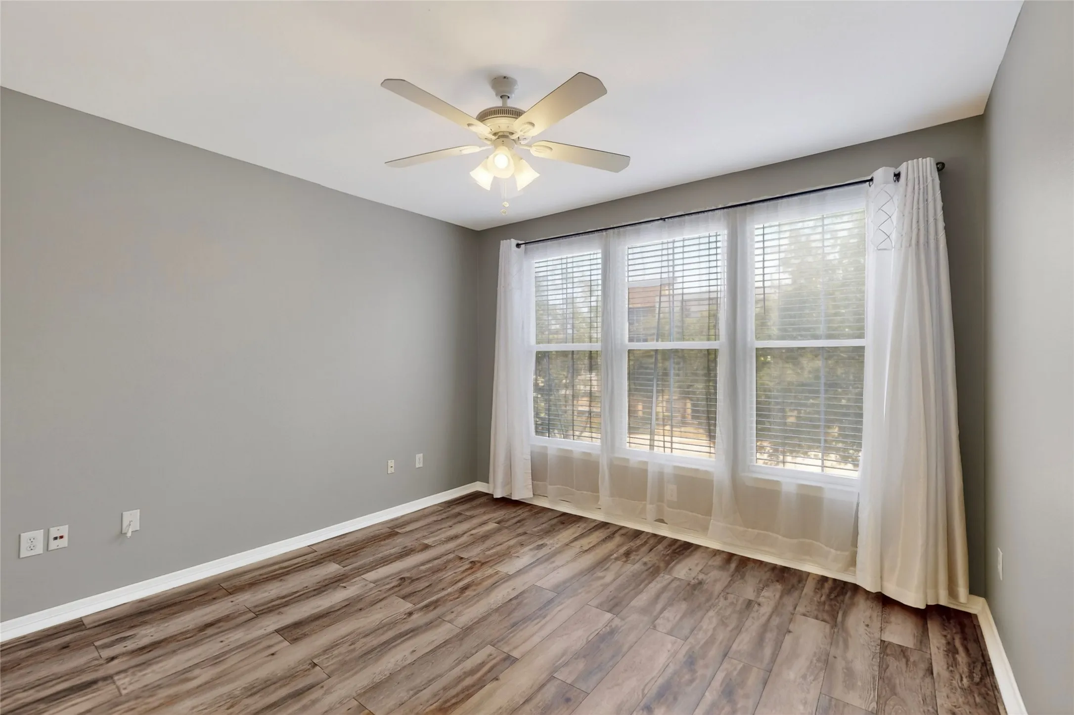 Spare room with wood finished floors and ceiling fan