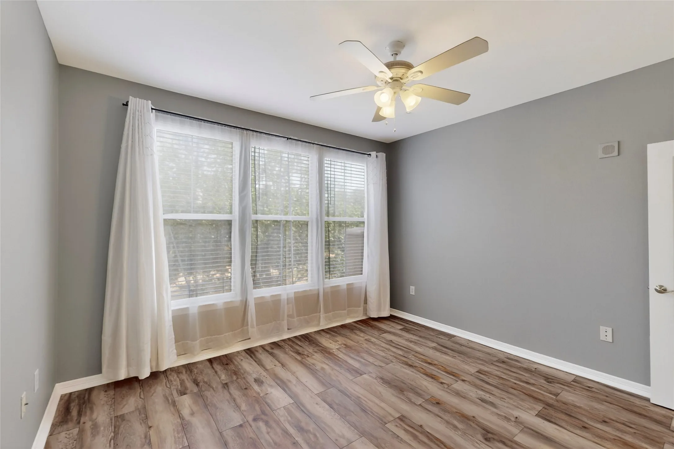 Spare room with wood finished floors and a ceiling fan