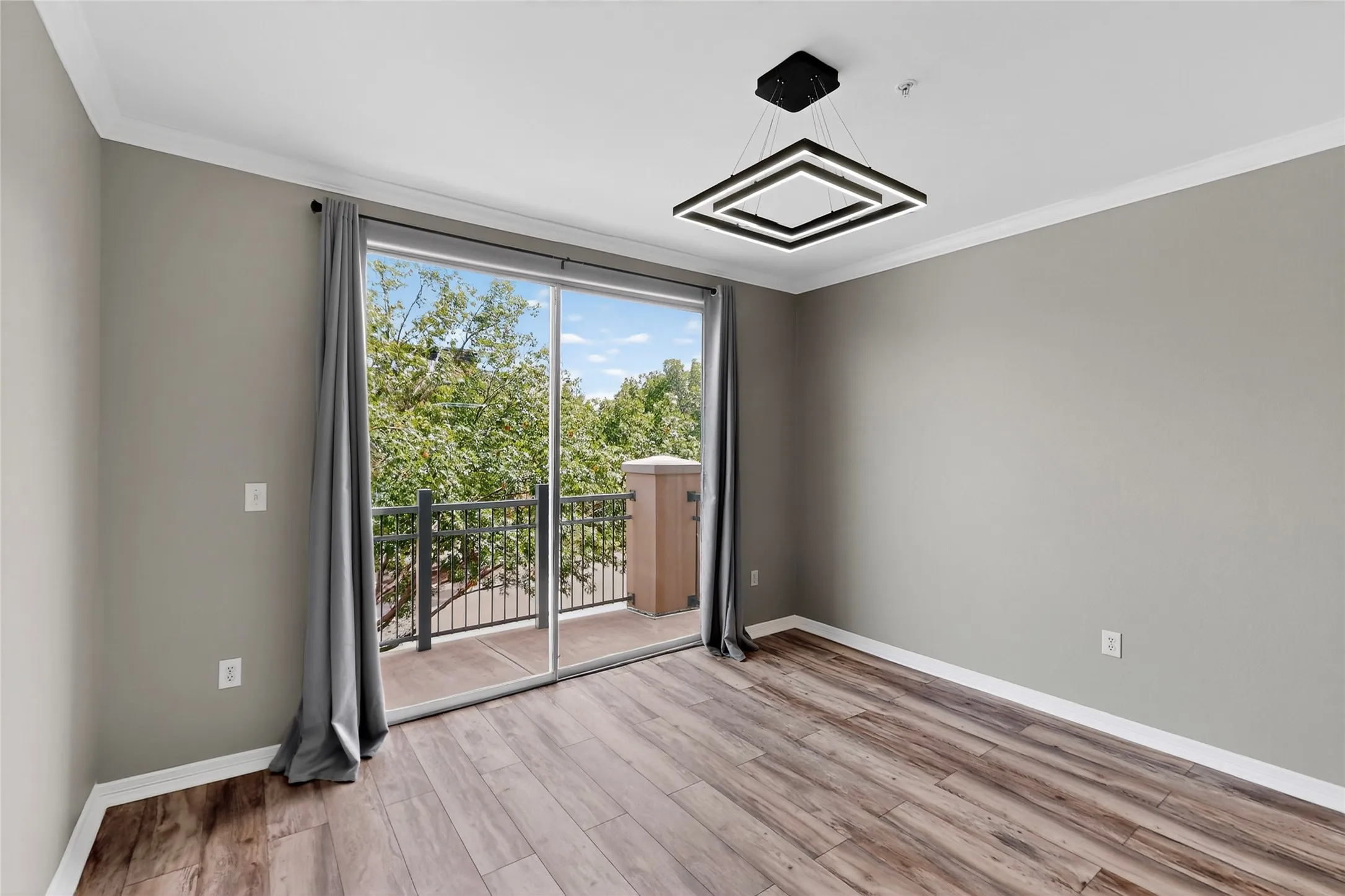 Spare room with wood finished floors and crown molding
