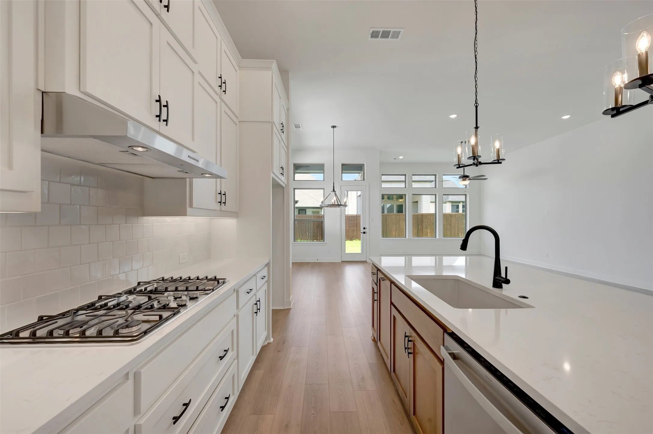 Gourmet kitchen with white cabinetry, subway tile backsplash, and stone countertops