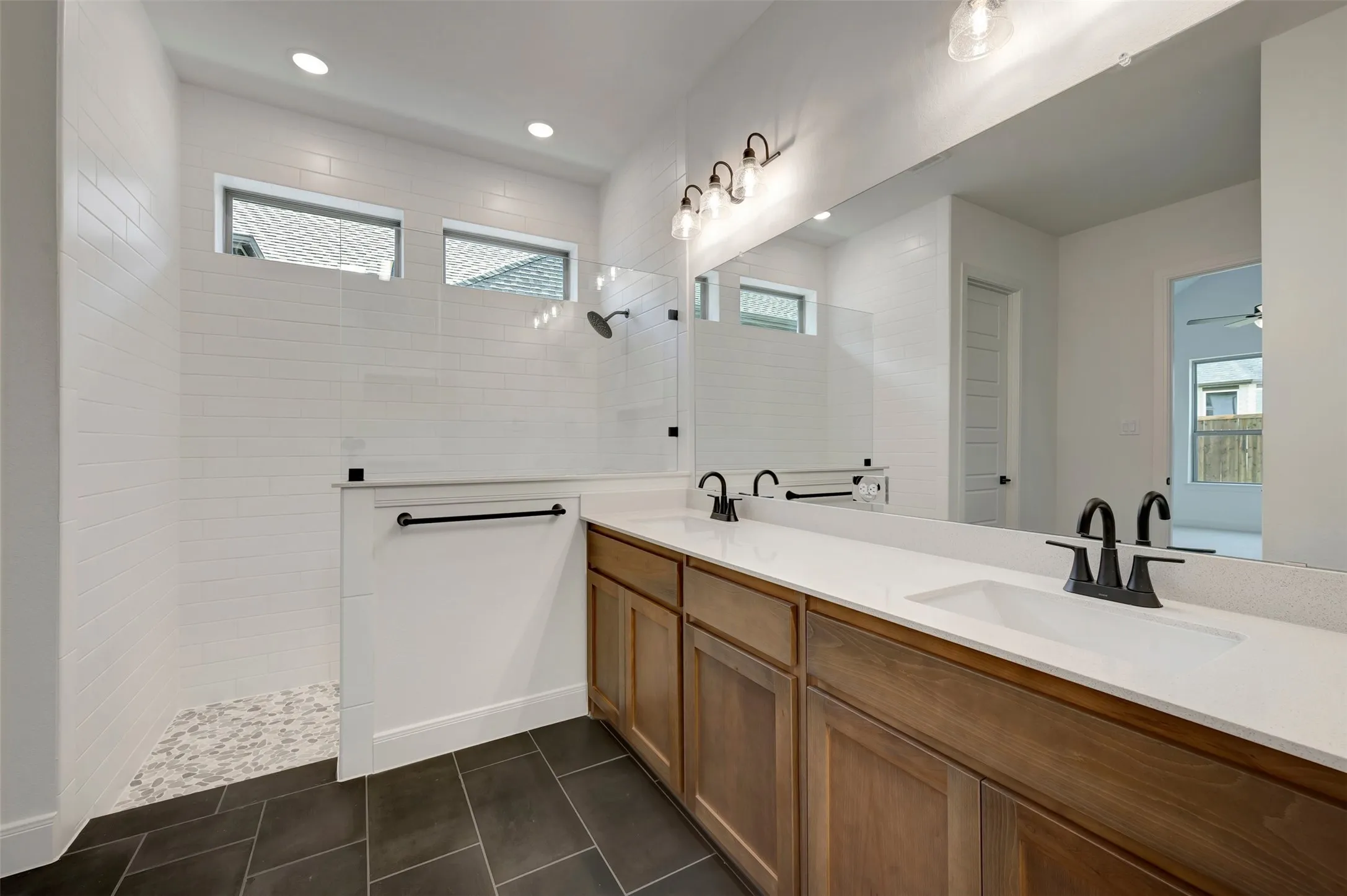 Dual vanity with undermount sinks, matte black fixtures, and a spacious mirror