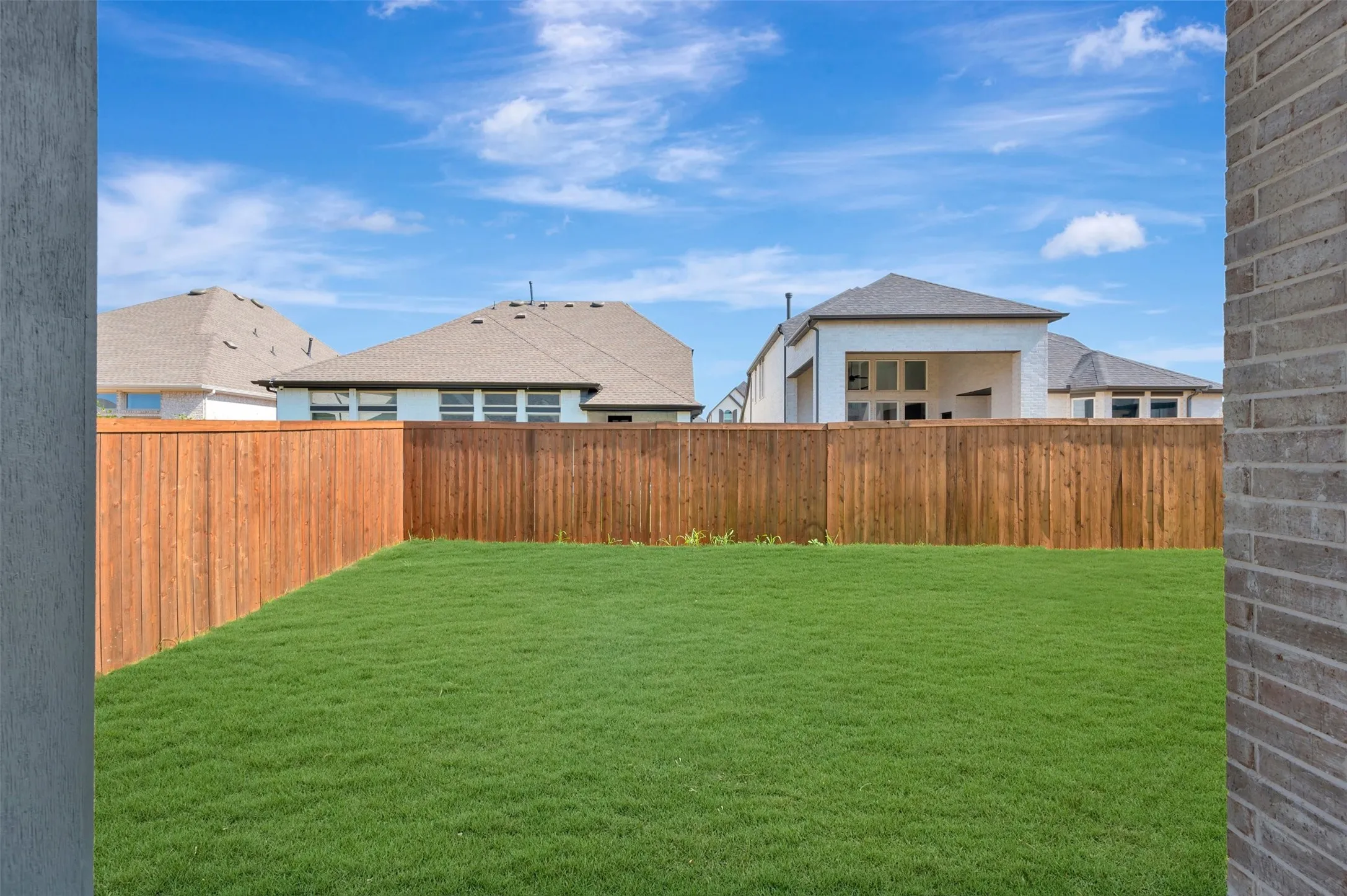 Expansive lawn with a wood-panel fence