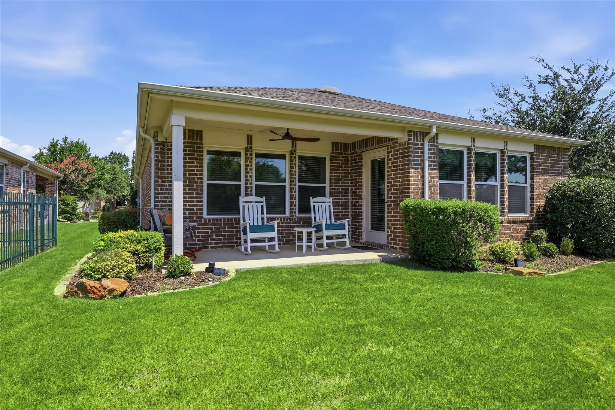 Brick exterior with a covered patio, featuring a ceiling fan and recessed lighting