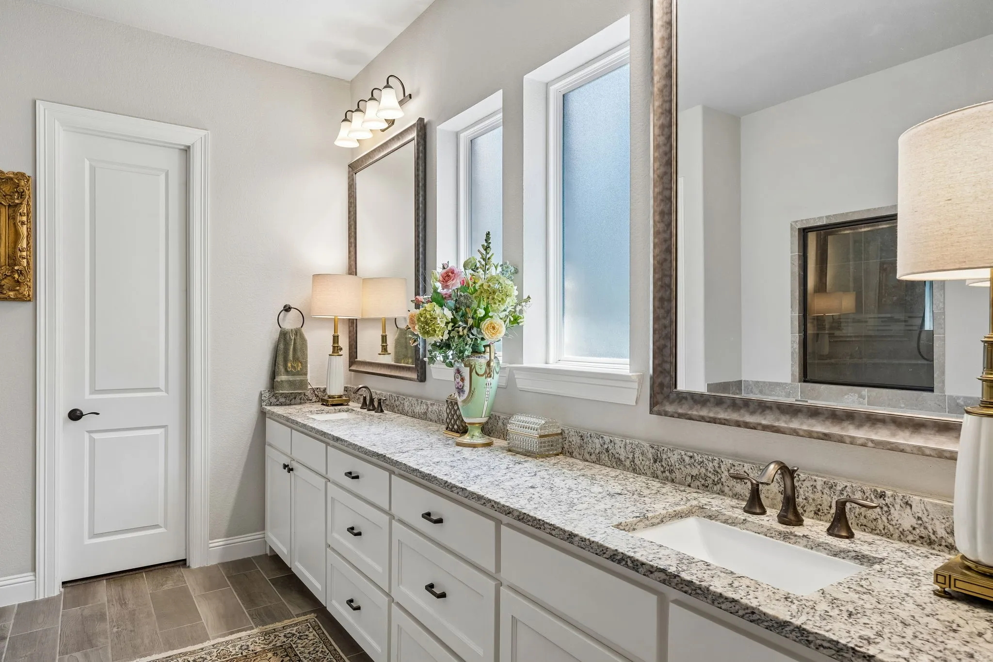 Granite countertops, dual sinks, large mirrors and lots of light add to this spa-like primary bath.