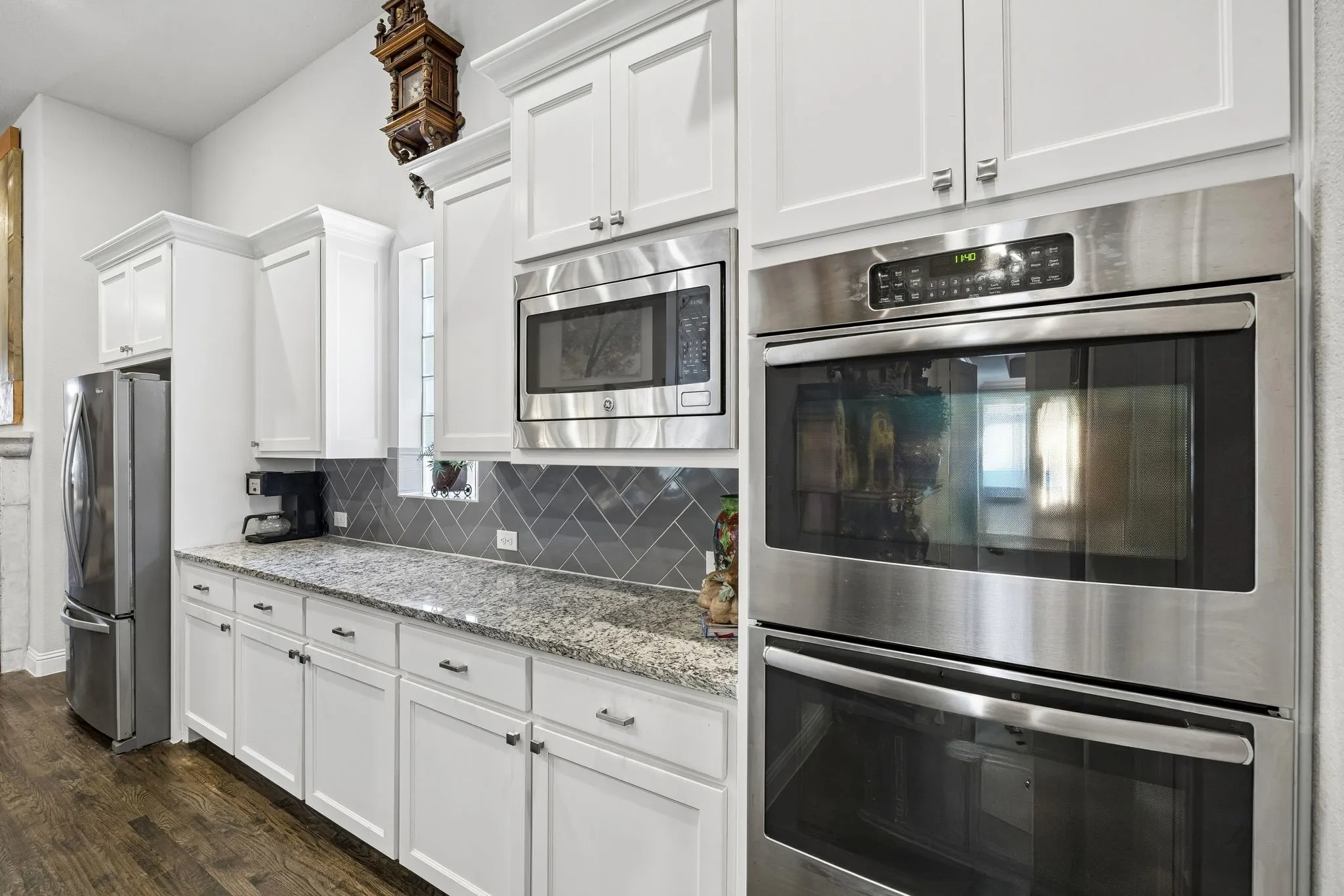Spacious serving space featuring numerous cabinets, GE microwave and double ovens.