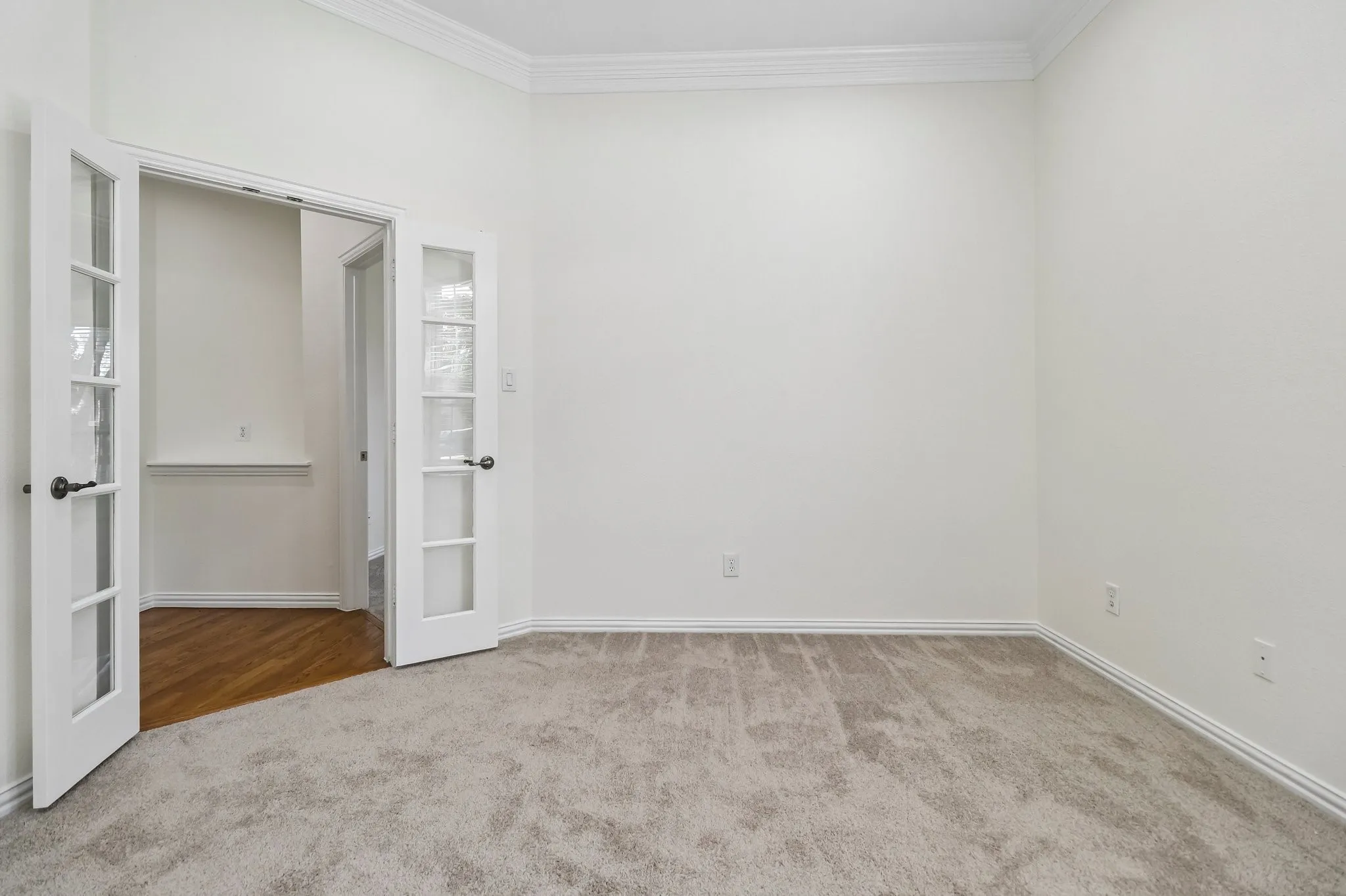 Flex room featuring French doors with glass inserts, double crown molding, and LED can lights.