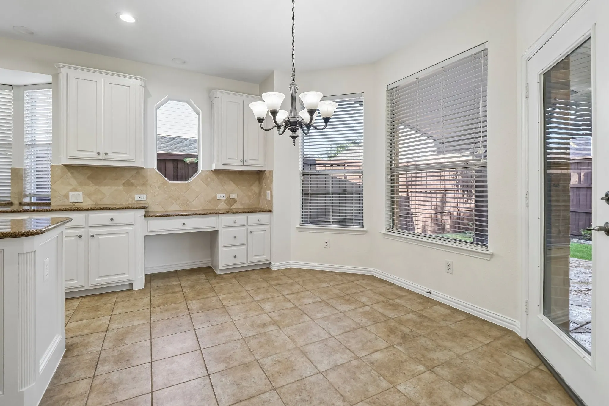 Large breakfast nook with bay window and built in desk.