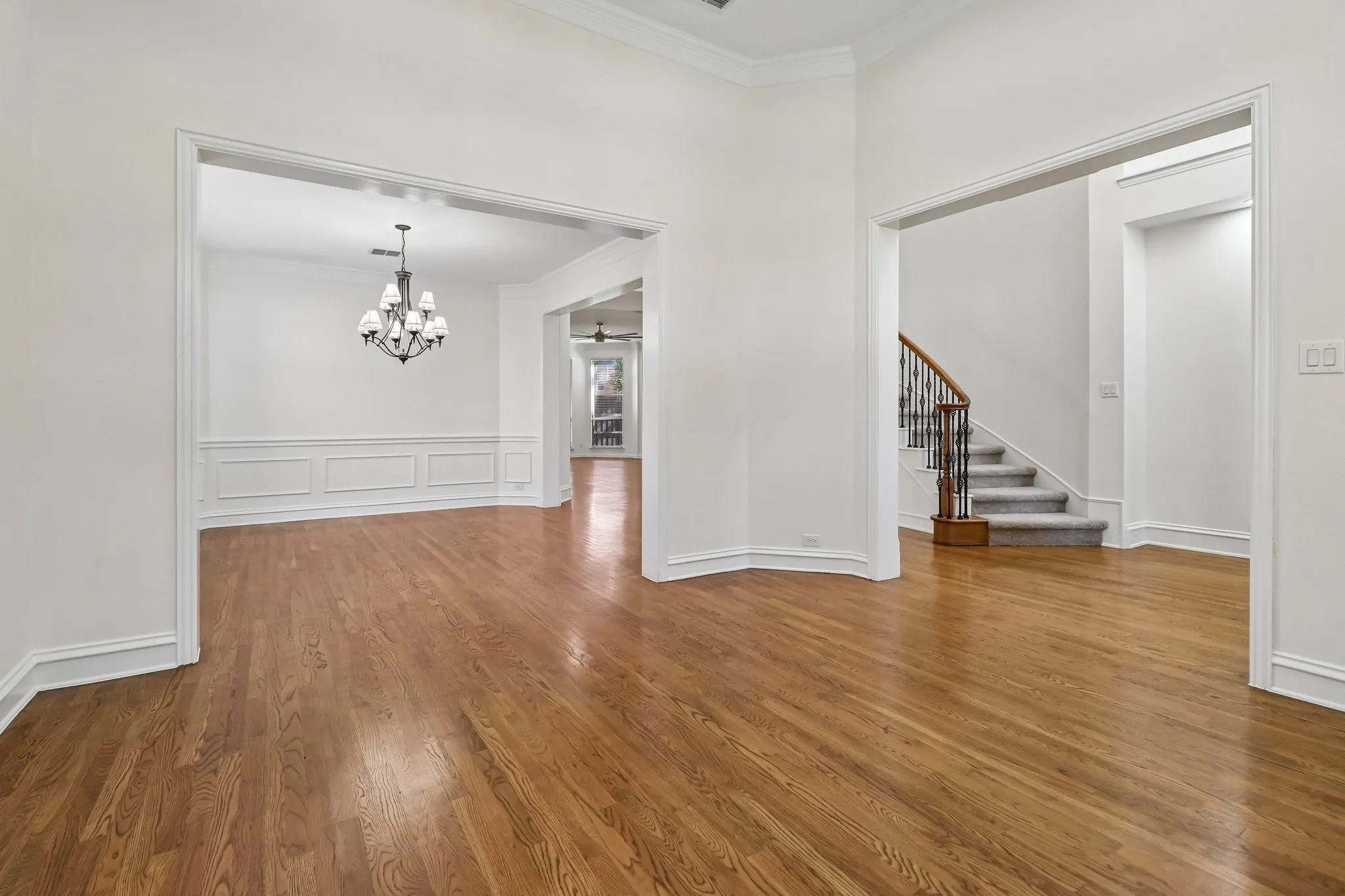 Formal living highlighted by tall ceilings, two cased openings, double staged crown moldings, hardwood floors and LED can lights in ceiling.