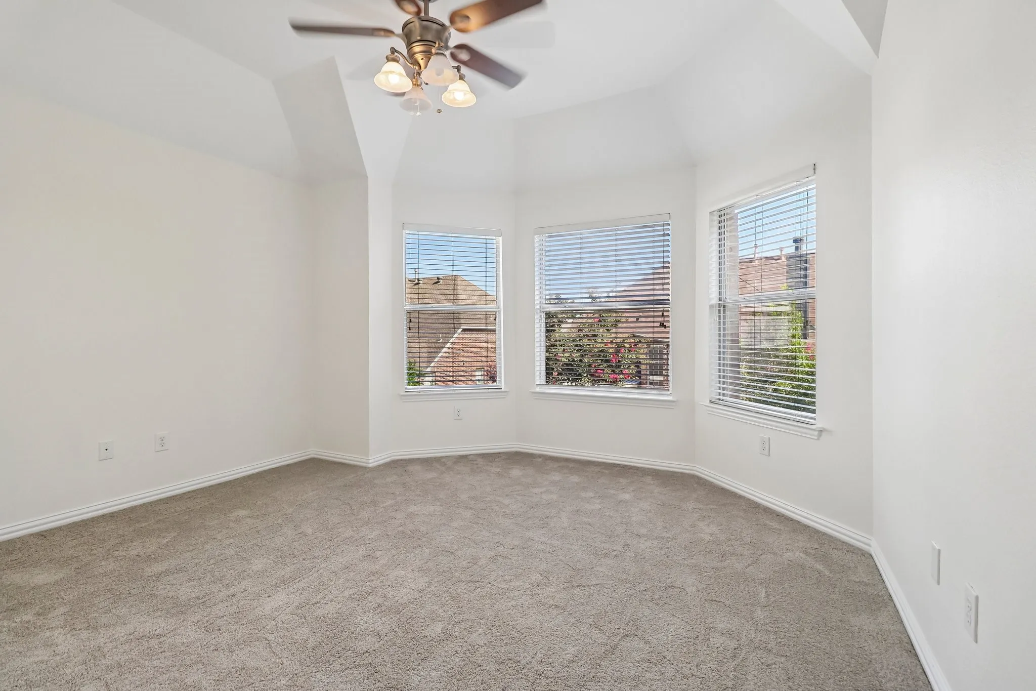 Upstairs bedroom has bay window, vaulted ceilings and ceiling fan.