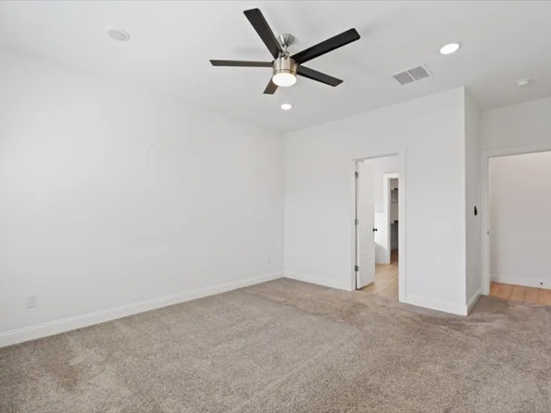 Room featuring neutral carpet flooring, white walls, and a contemporary ceiling fan with integrated lighting
