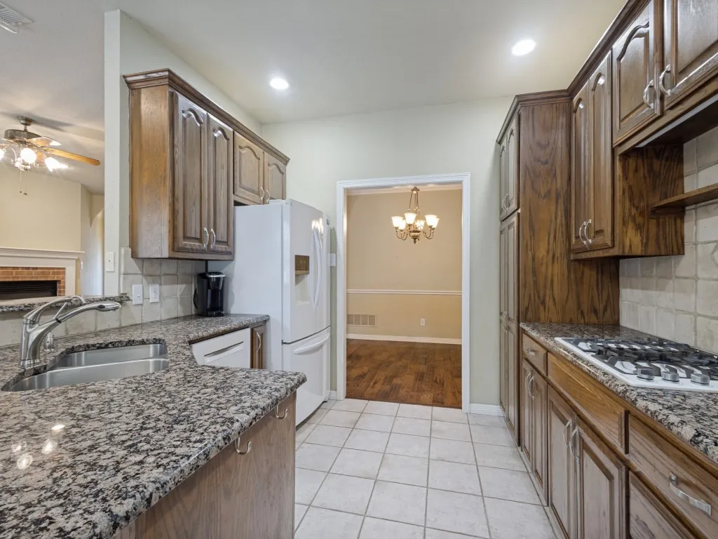 The kitchen has granite countertops, gas cooktop, and plenty of storage.