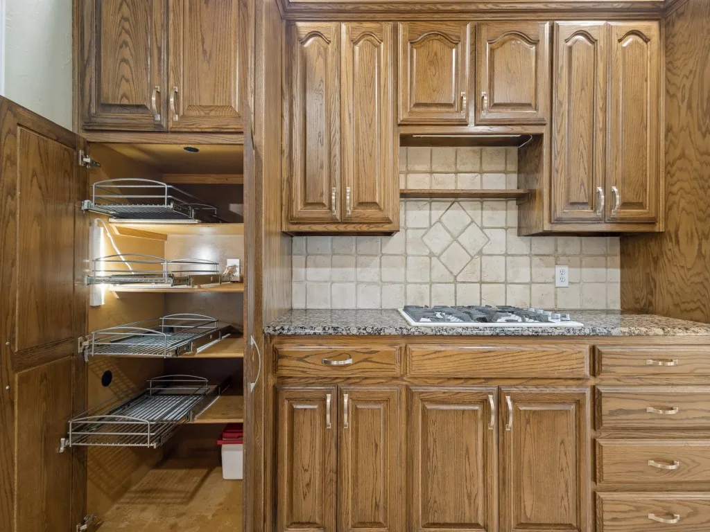 Pullout shelving maximizes the space in this deep pantry.  The shelf above the cooktop is great for holding spices or decorative items.