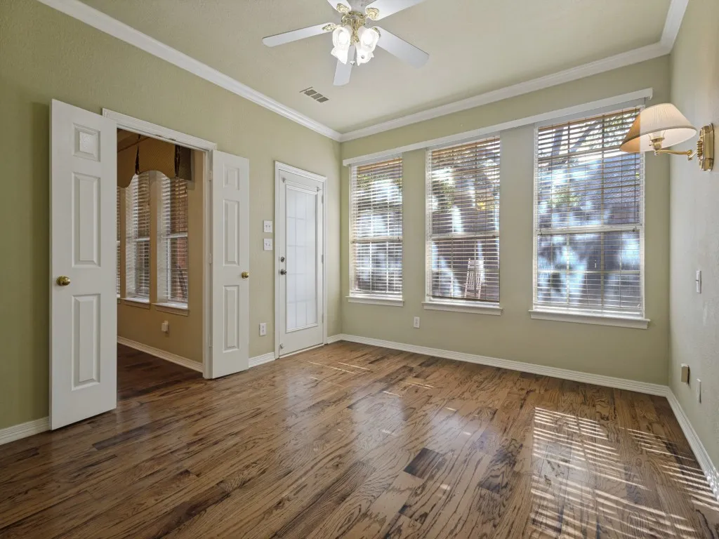 Crown molding, wall lighting and double doors are special features that make this bedroom stand out. Beautiful wall of windows overlooking the backyard.