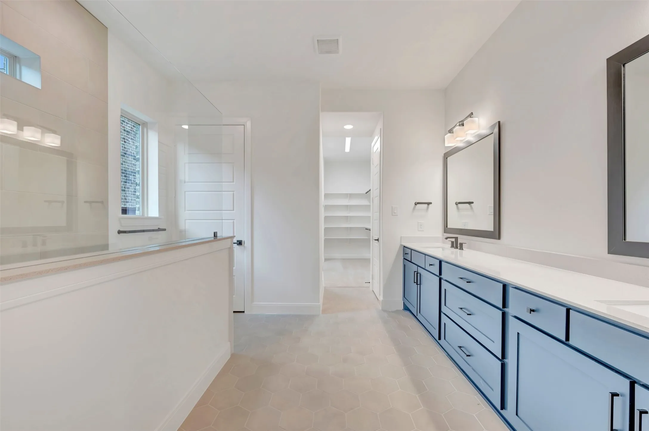 Dual vanity with blue cabinetry, white countertops, and integrated sinks