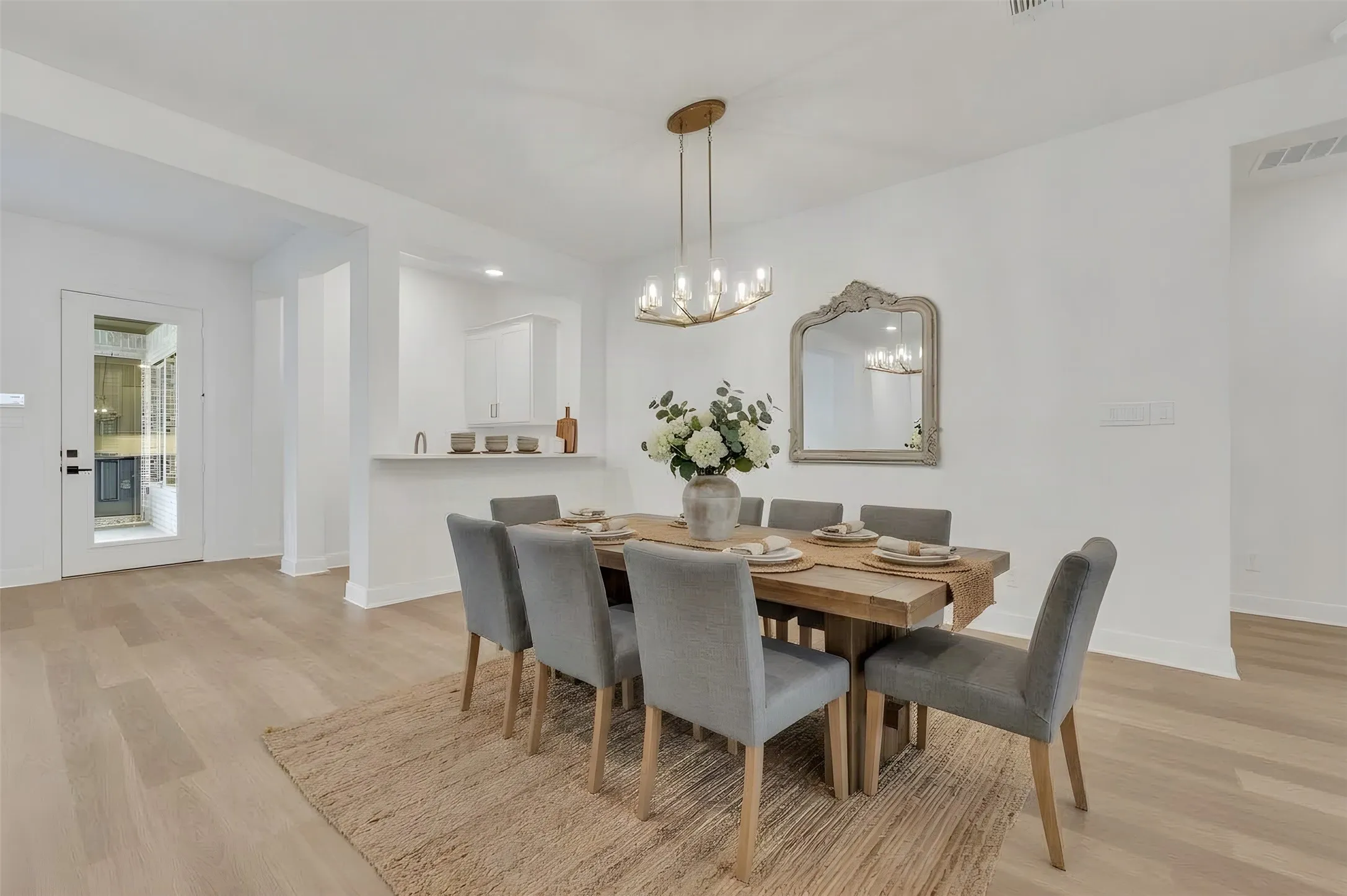 Light wood-finish flooring throughout, framed by bright white walls