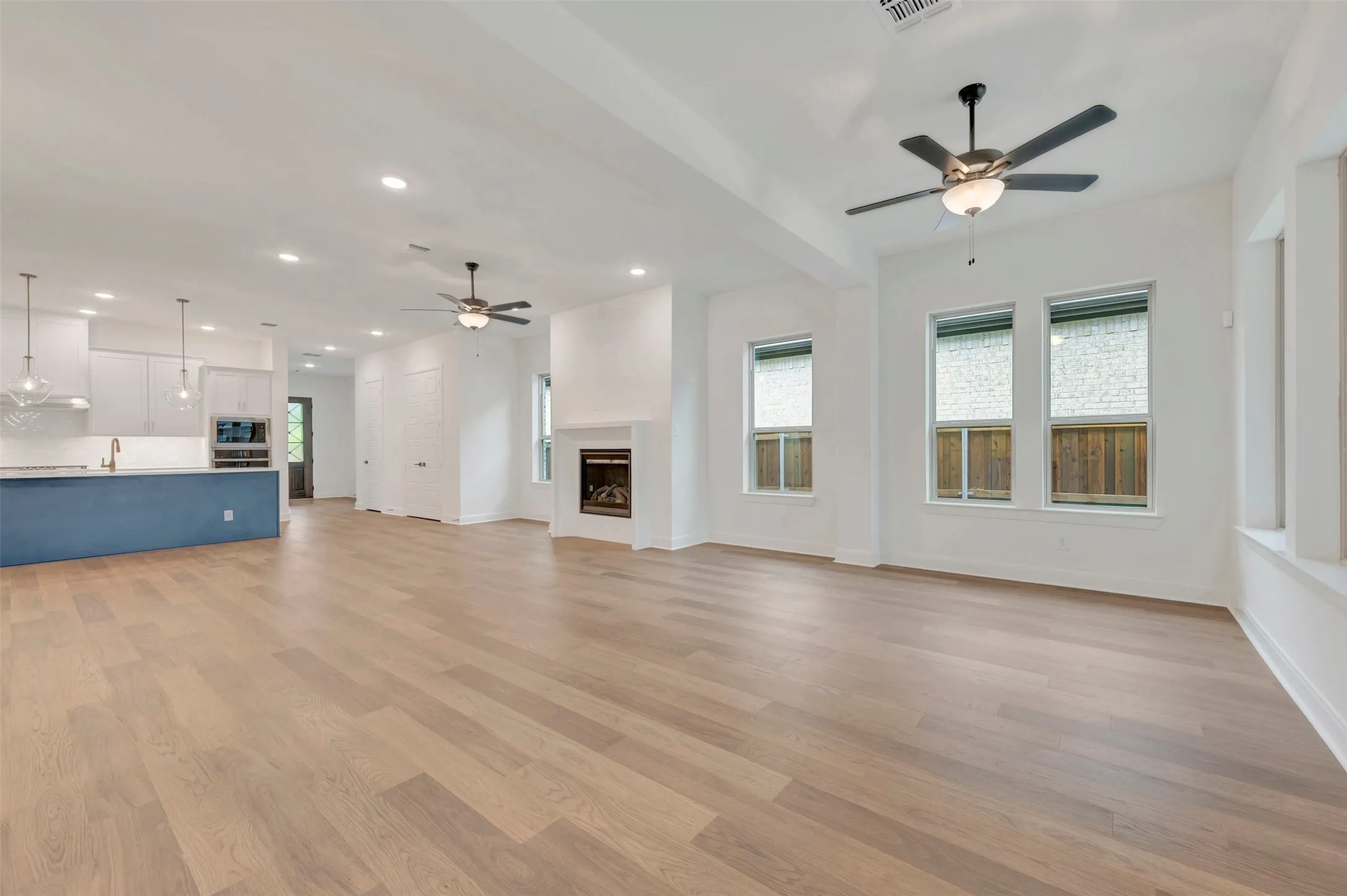 Open-concept layout featuring wood-finish flooring, recessed lighting, and ceiling fans
