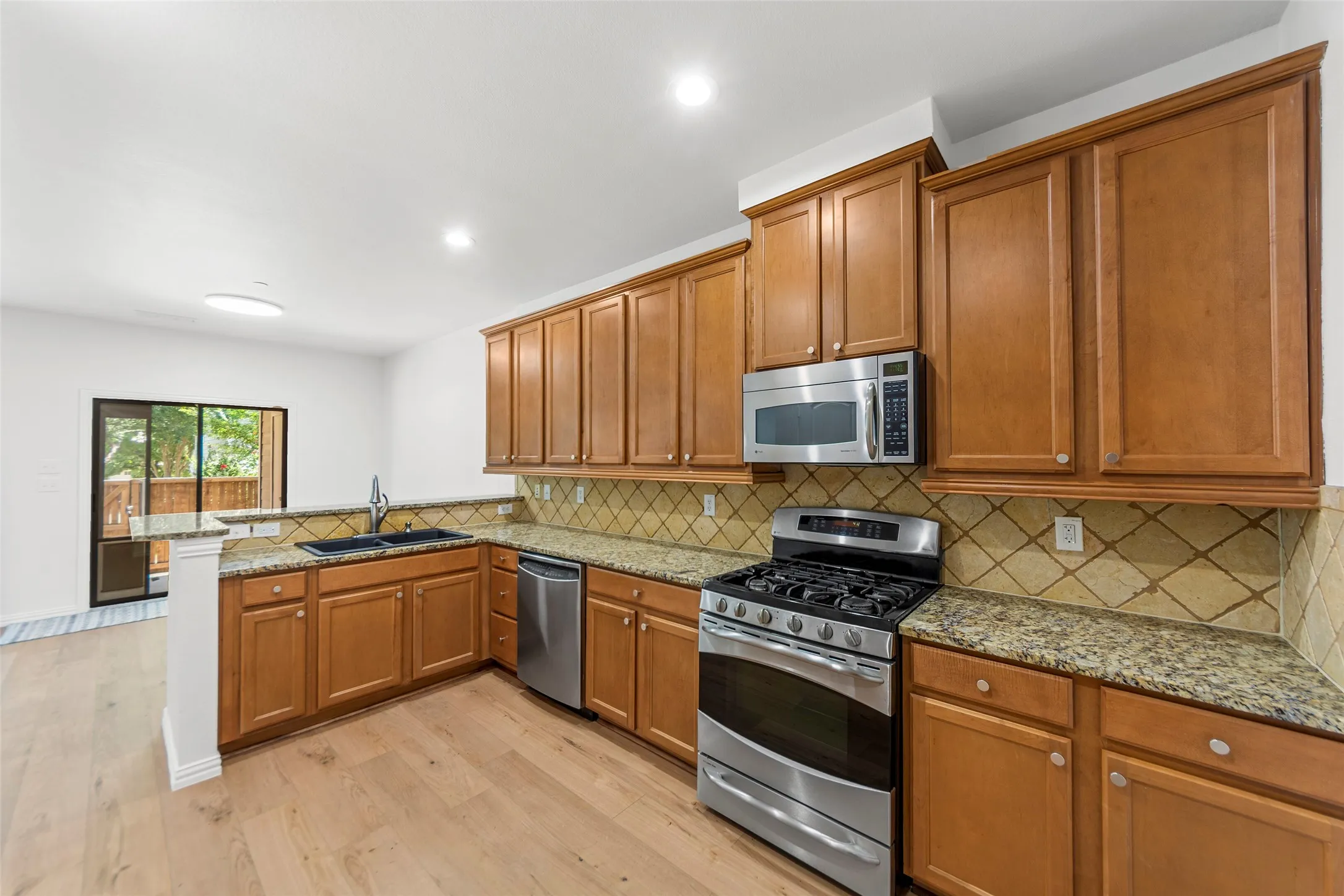 Kitchen featuring wood-finish cabinetry, granite countertops, and stainless steel appliances