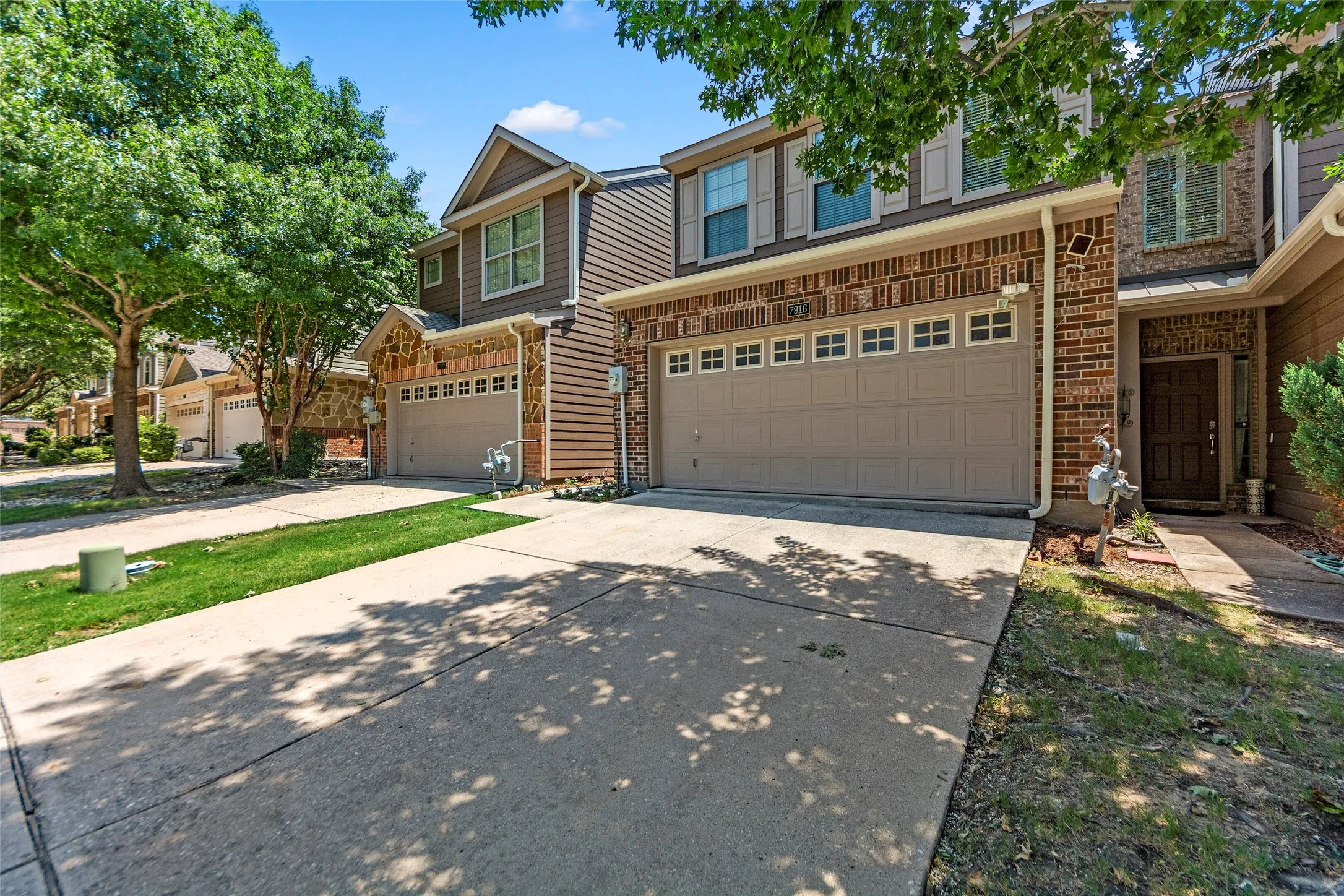 Exterior featuring brick and siding facade, an attached two-car garage, and a concrete driveway
