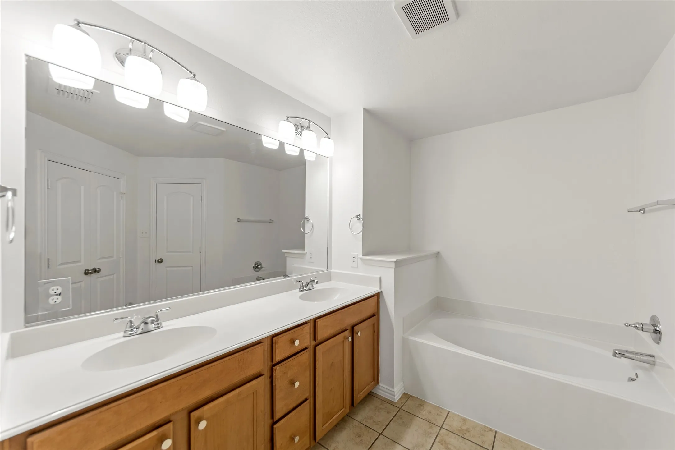 Bathroom featuring a double vanity with white countertops and wood cabinetry