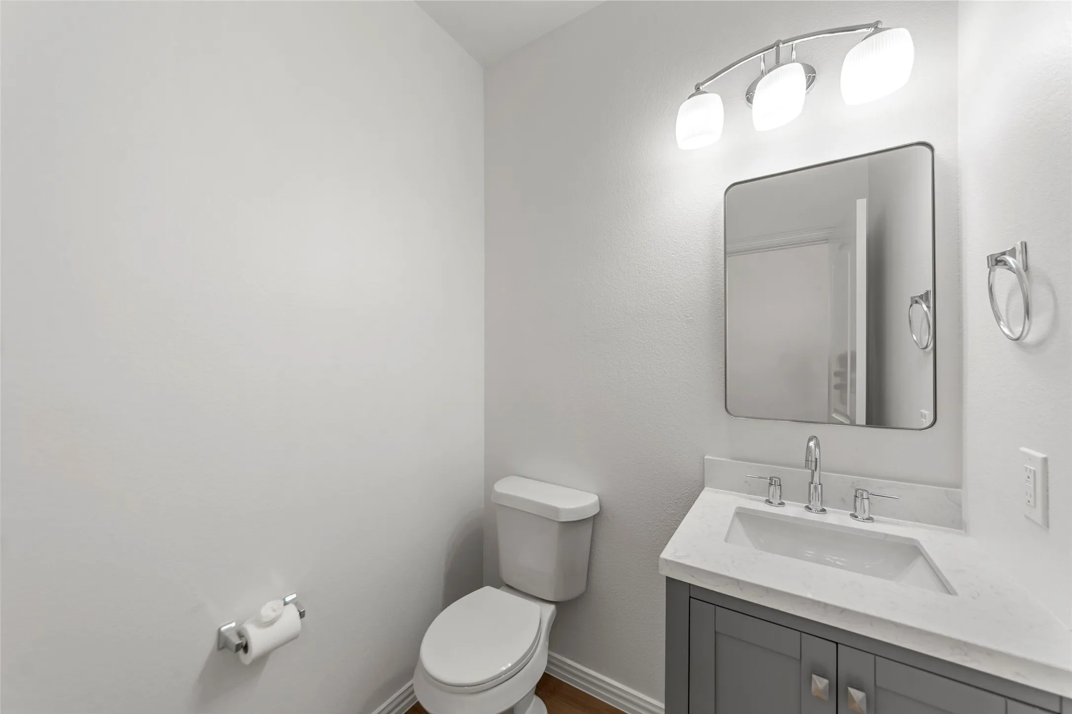 Bathroom featuring a modern vanity with gray cabinetry, a light-toned countertop, and a rectangular undermount sink