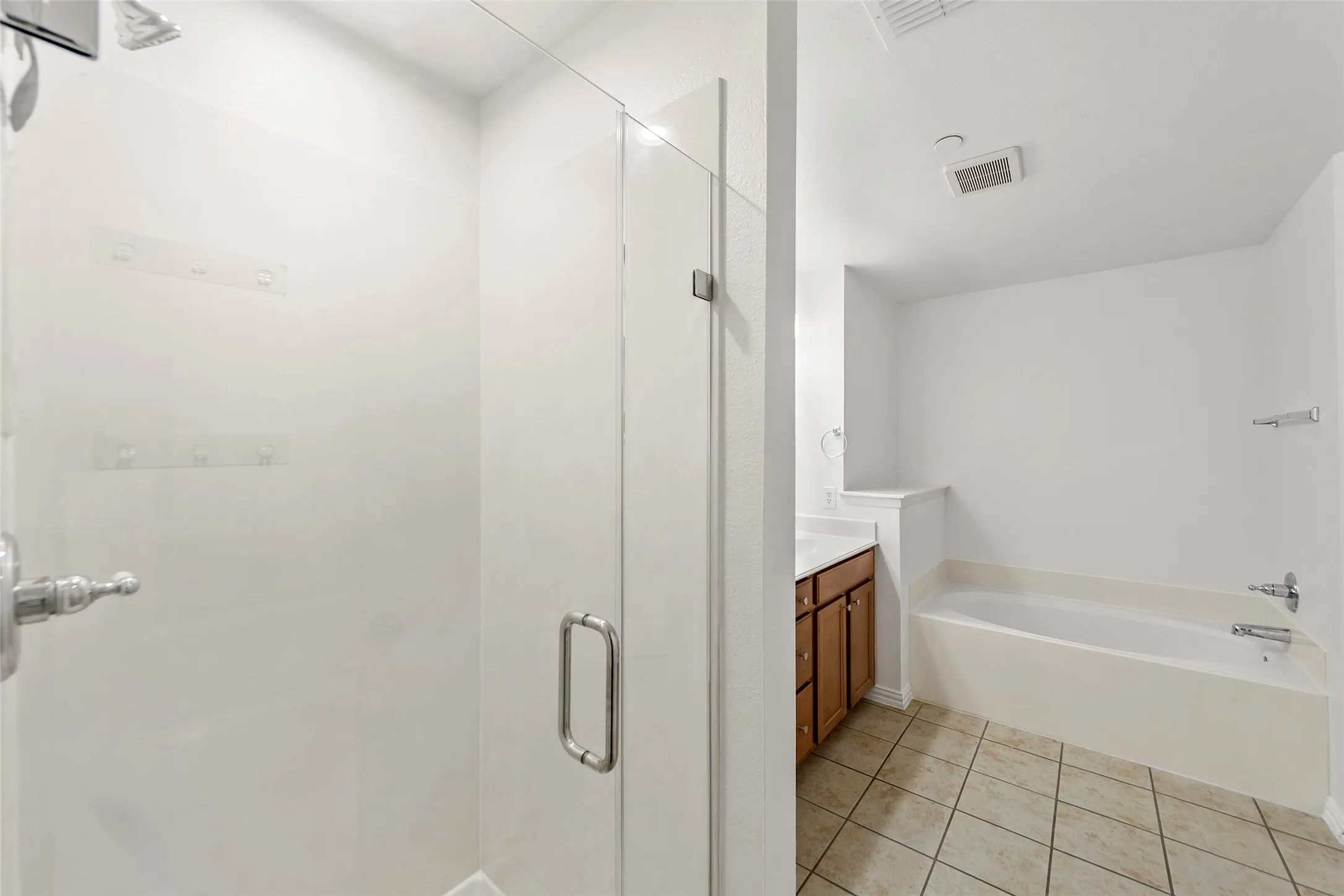 Glass-enclosed shower with chrome fixtures