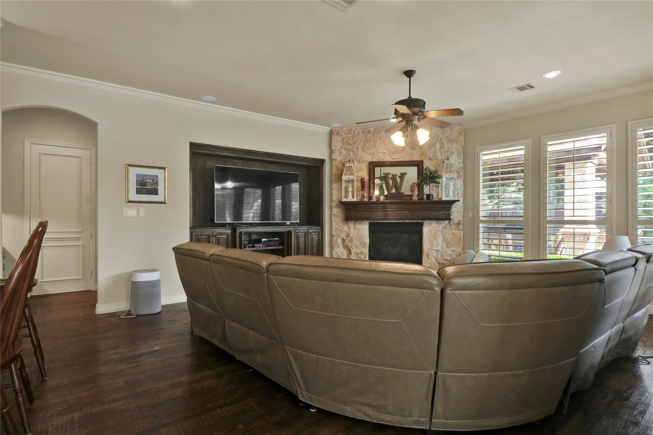 Living room with built in cabinet space, stone fireplace with mantel.