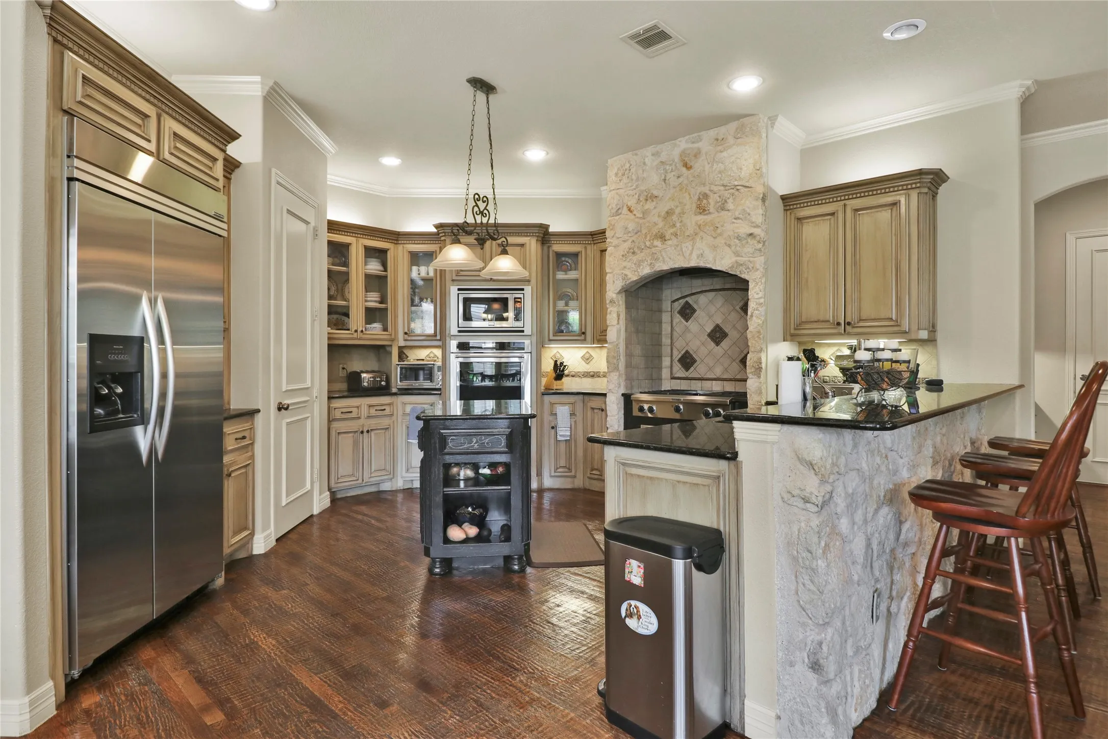 Kitchen with breakfast bar, built in fridge and island.