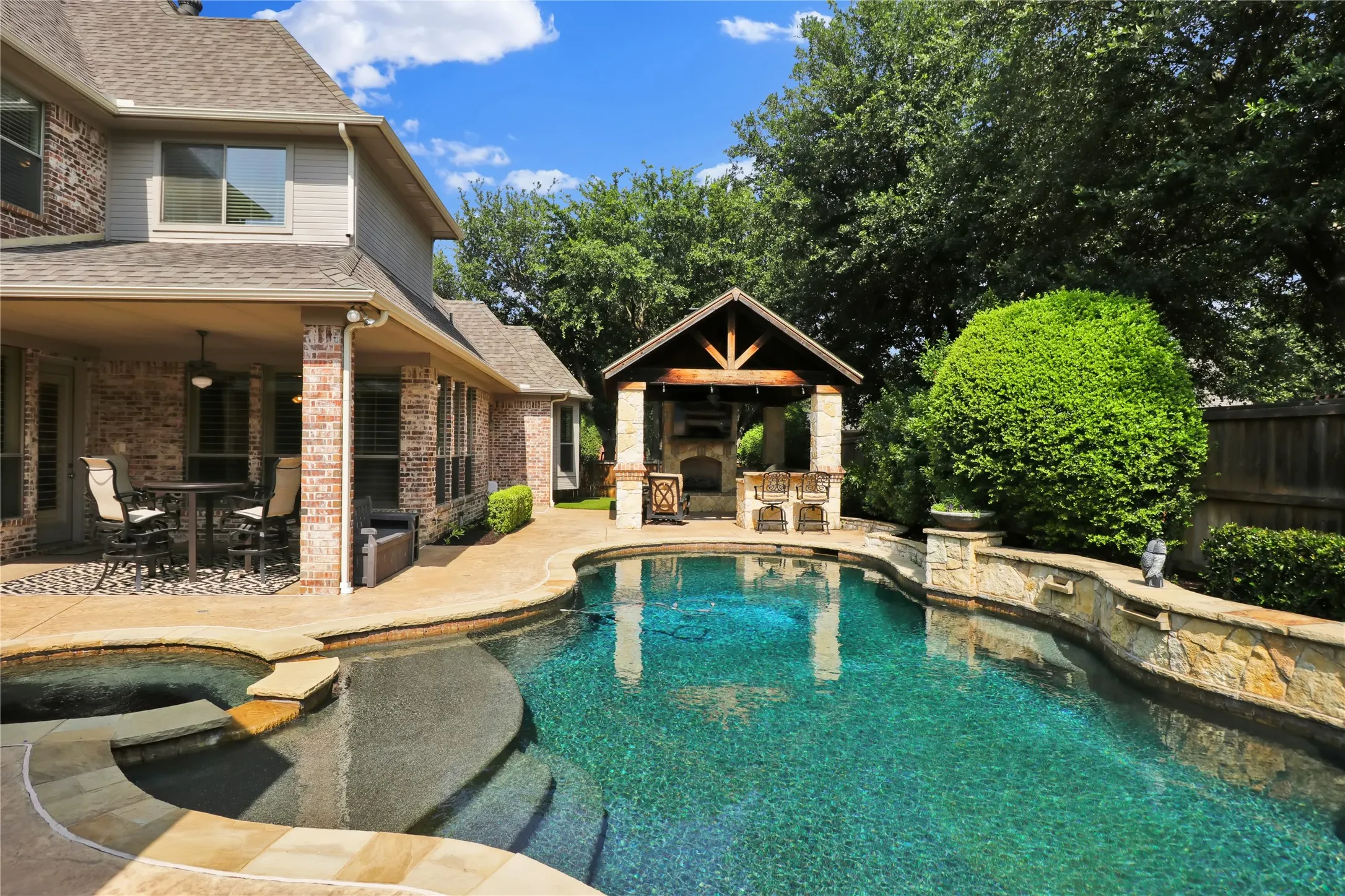 Covered patio, outdoor living space with grill and fireplace and pool is open!