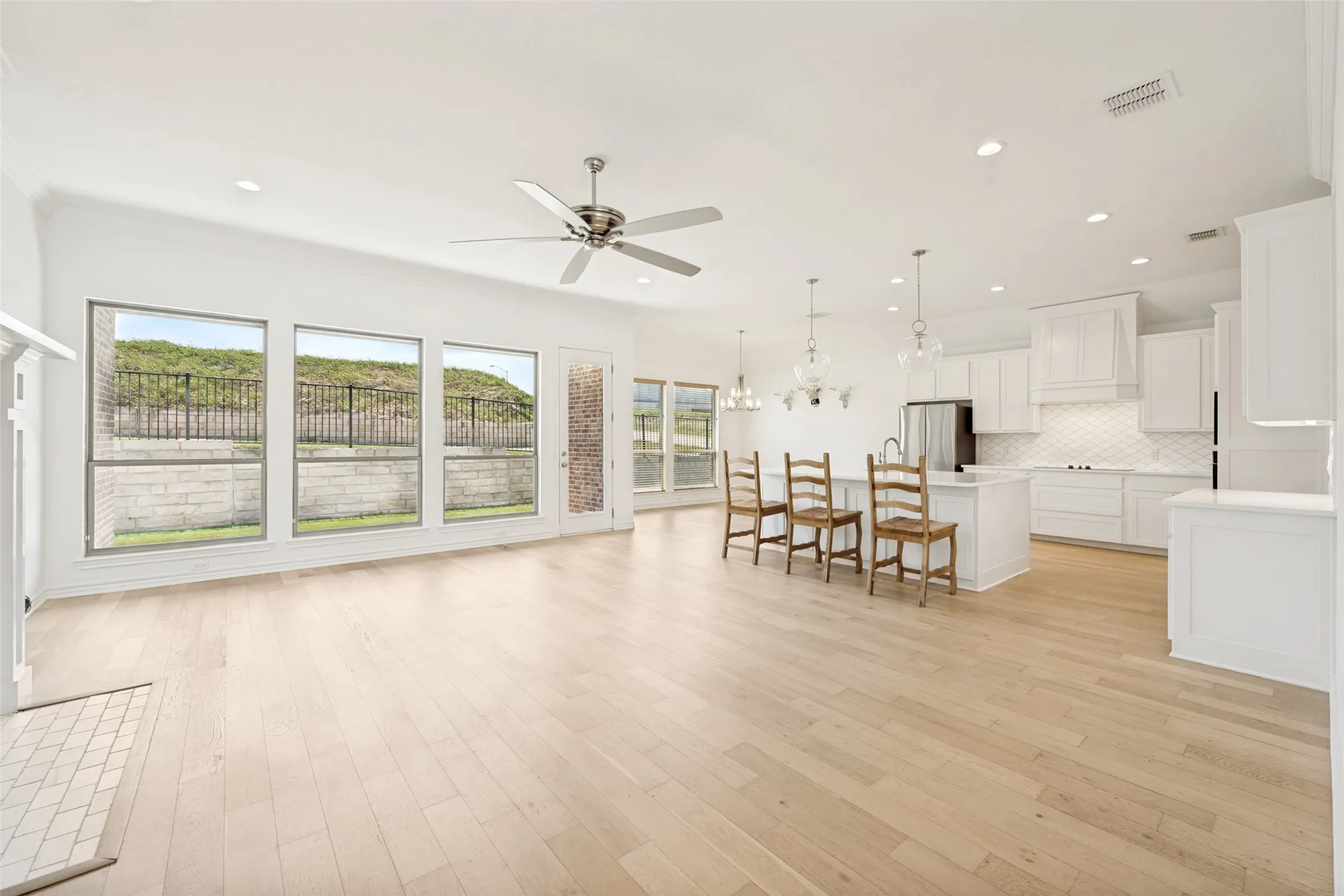 Open-concept living space featuring wood-finish flooring, recessed lighting, and a ceiling fan