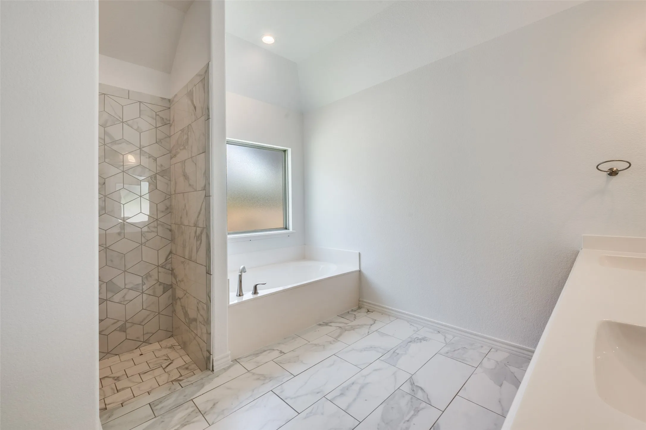 Walk-in shower with geometric tile surround, built-in niche, and mosaic tile floor