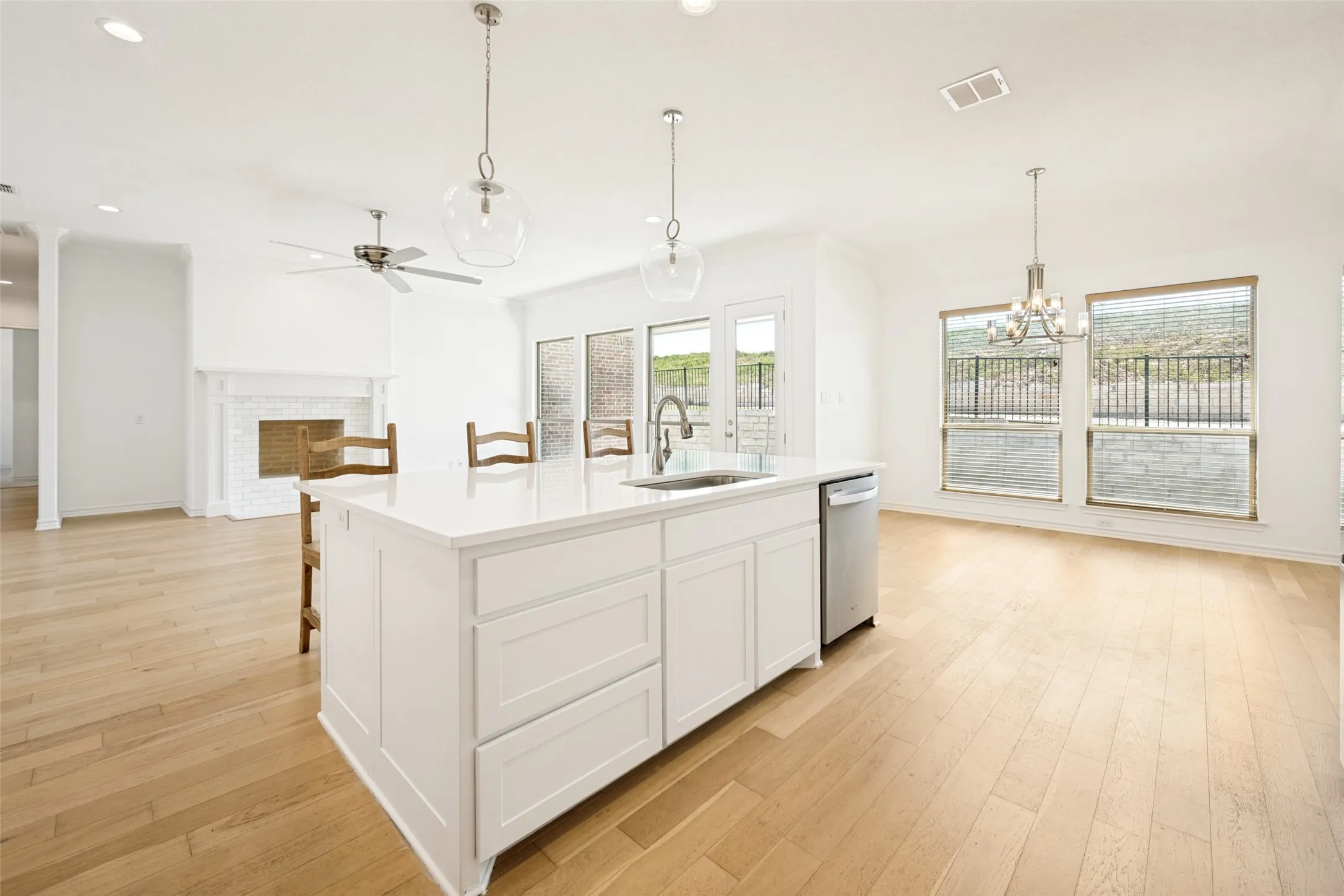 Modern kitchen island with white cabinetry, integrated sink, and stainless steel dishwasher