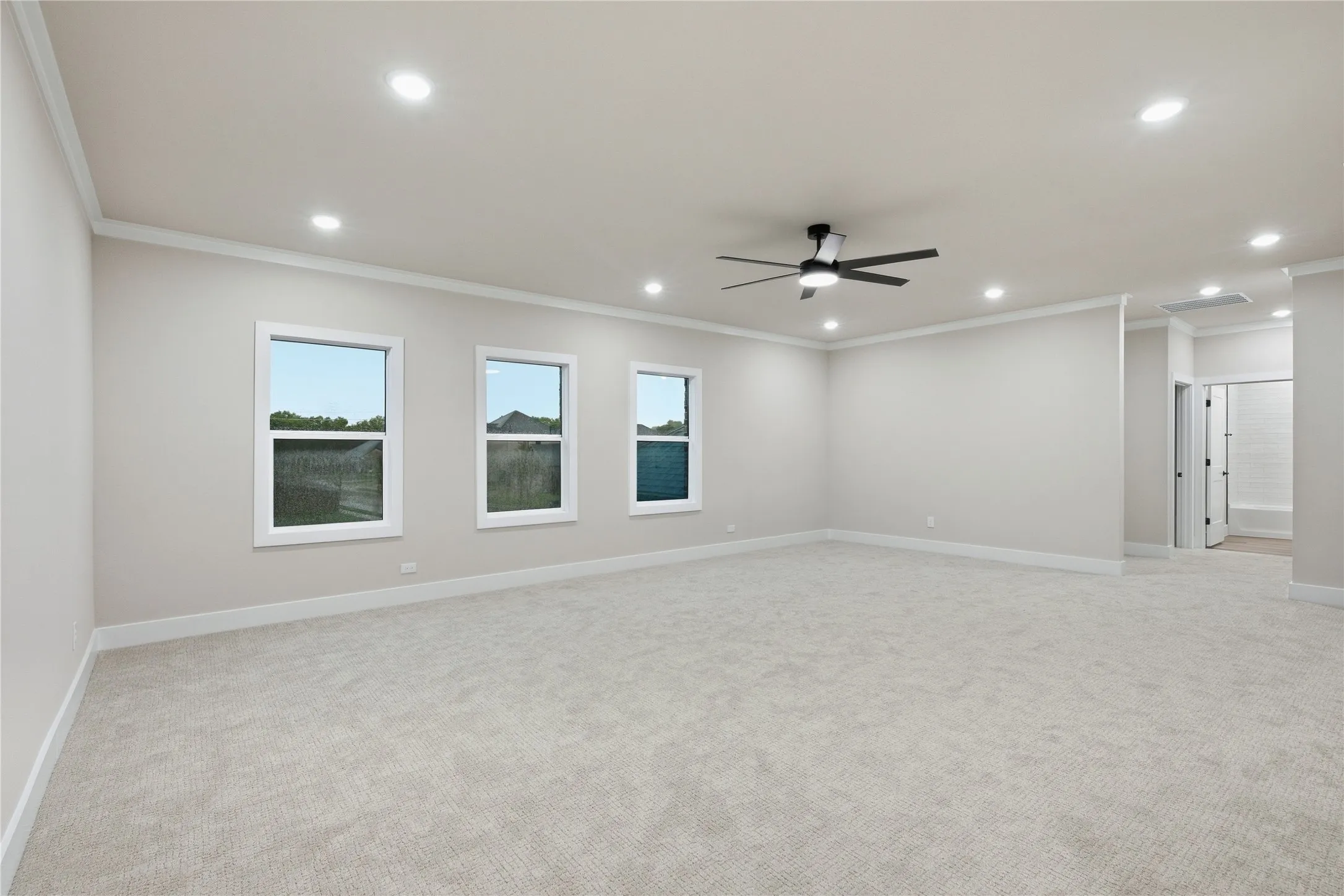 Recessed lighting, ceiling fan, crown molding, light-toned carpet, and multiple windows