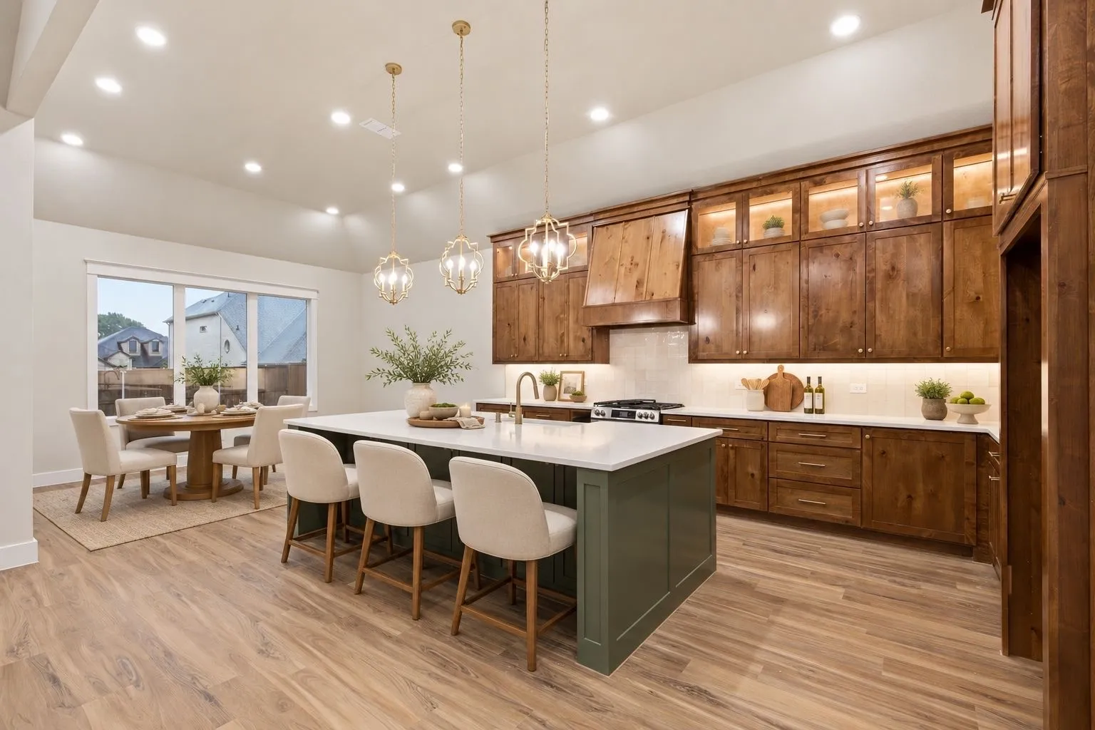 Wood-finish flooring extending into the kitchen, a large center island with seating, dark wood cabinetry, and a white tile backsplash
