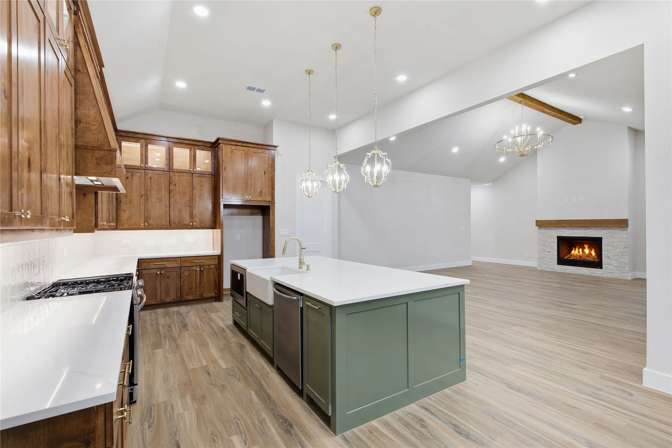 Vaulted ceilings, wood-finish flooring, and a stone-clad fireplace with a wood mantle