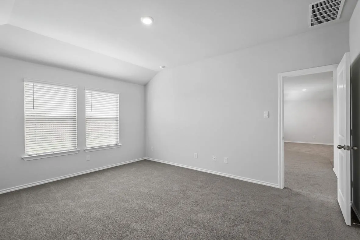 Bedroom featuring vaulted ceiling, recessed lighting, dual windows with blinds, gray carpeting, and white trim
