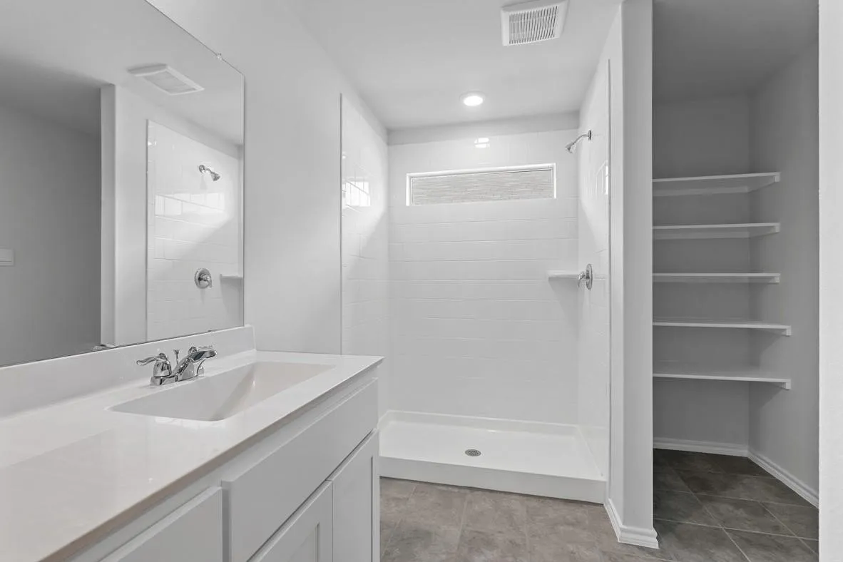 Contemporary bathroom featuring a white vanity with a rectangular sink, a large wall mirror, and a walk-in shower with white subway tile
