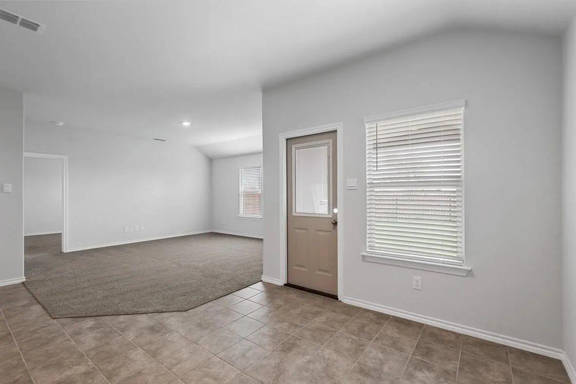 Tiled entry with a neutral-toned door featuring an upper glass panel