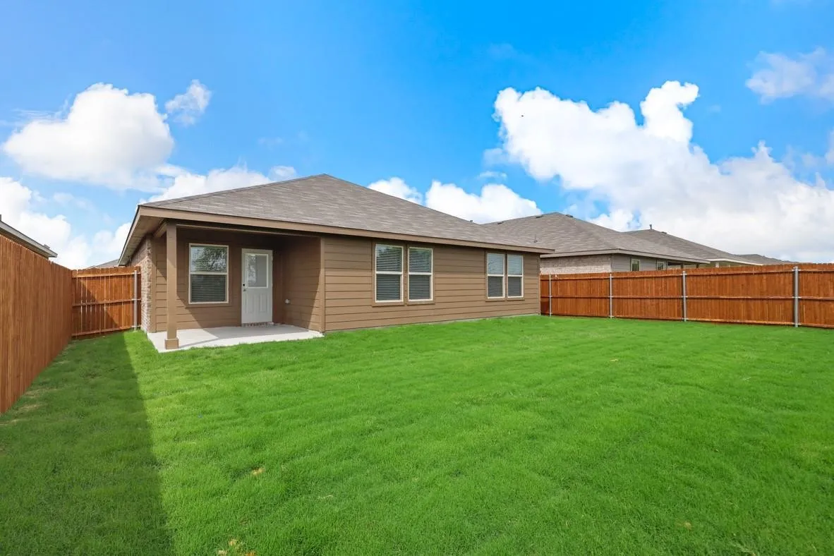Expansive green lawn with a newly installed wood privacy fence