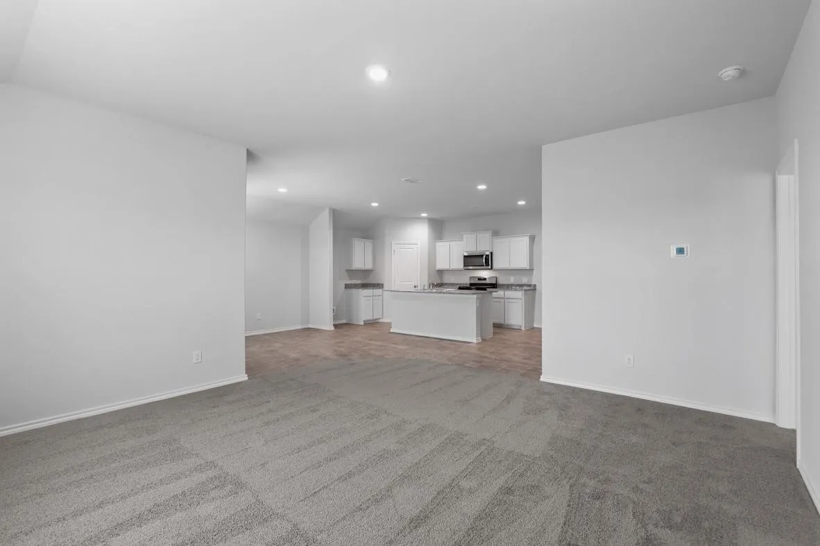 Open-concept living space featuring gray carpet flooring and recessed lighting
