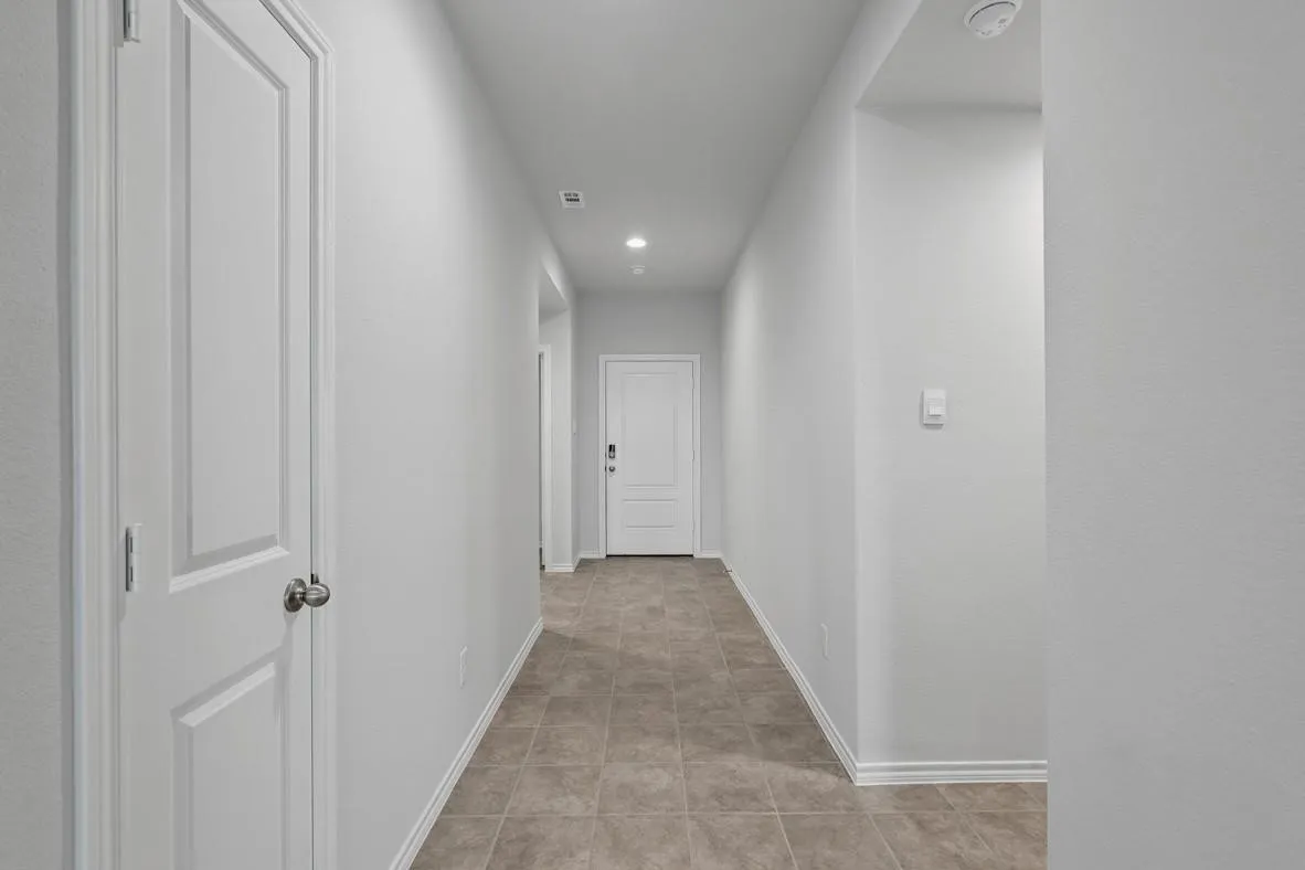 Hallway featuring tile flooring, recessed lighting, and white baseboards