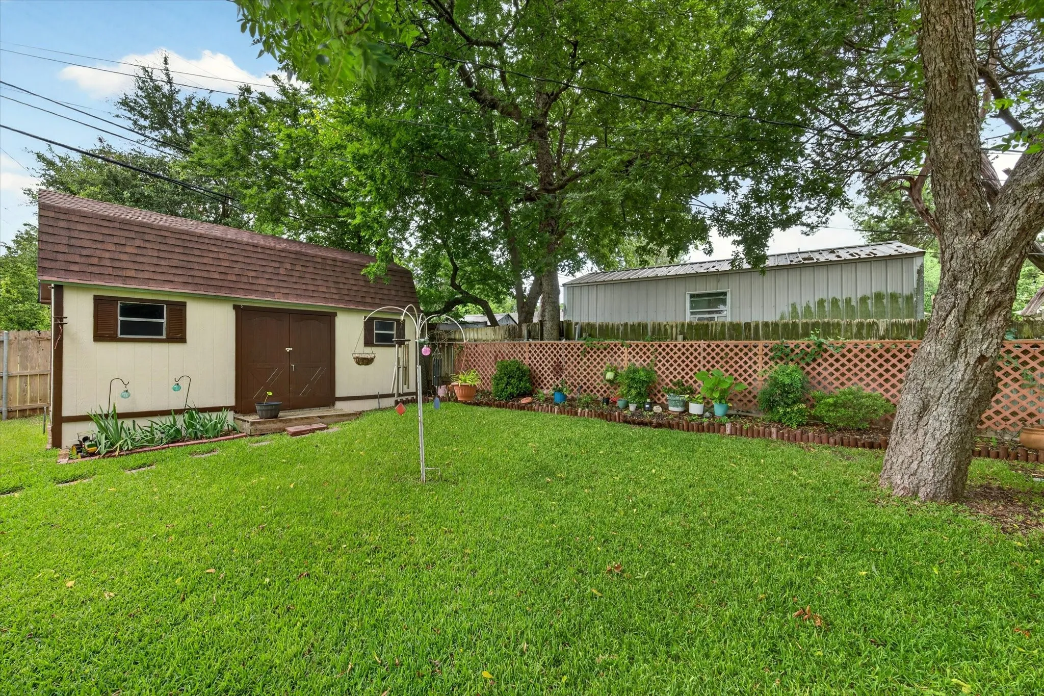 Expansive backyard featuring a lush lawn and mature trees
