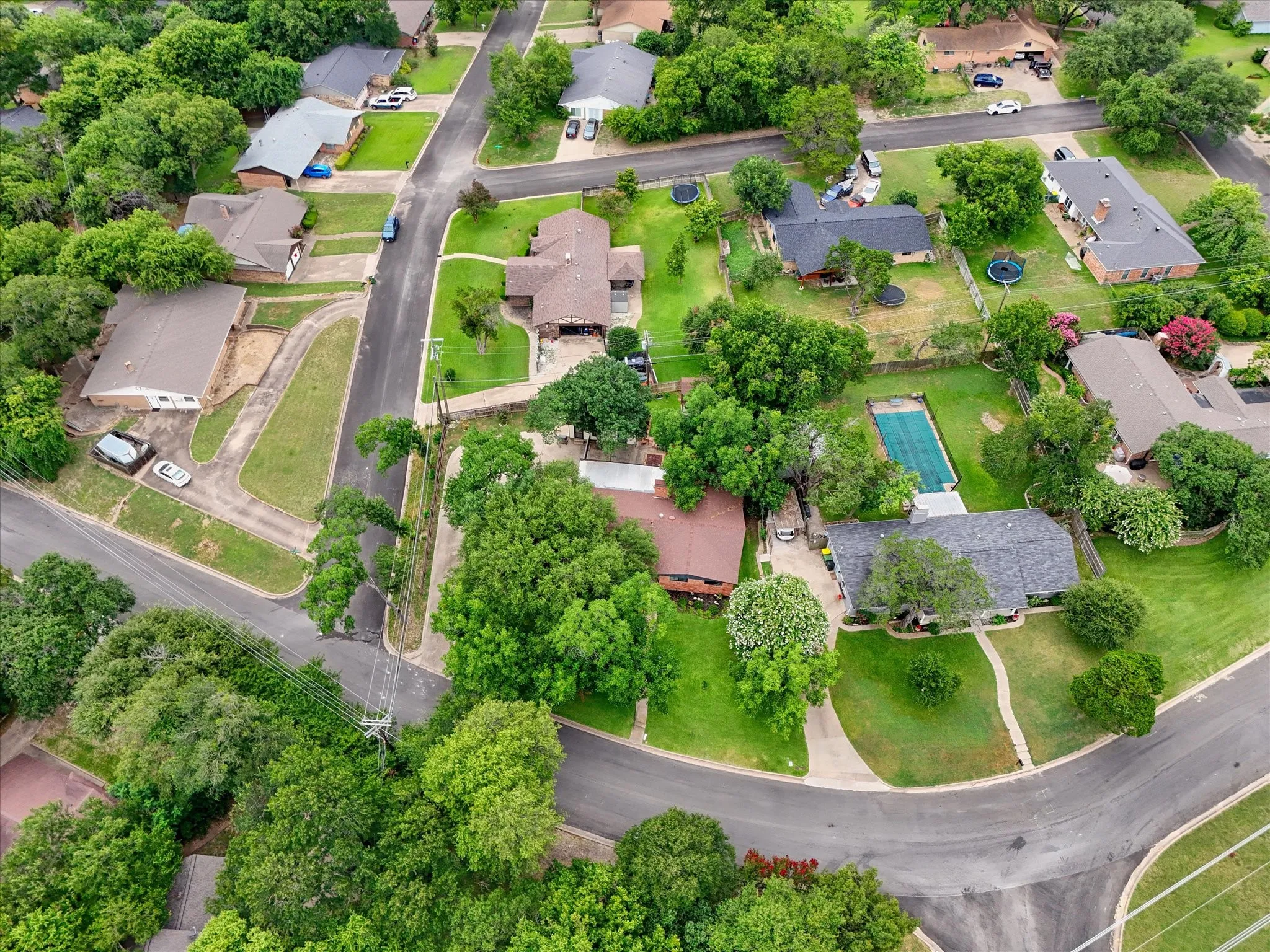 Aerial perspective showcasing a residential neighborhood with mature trees